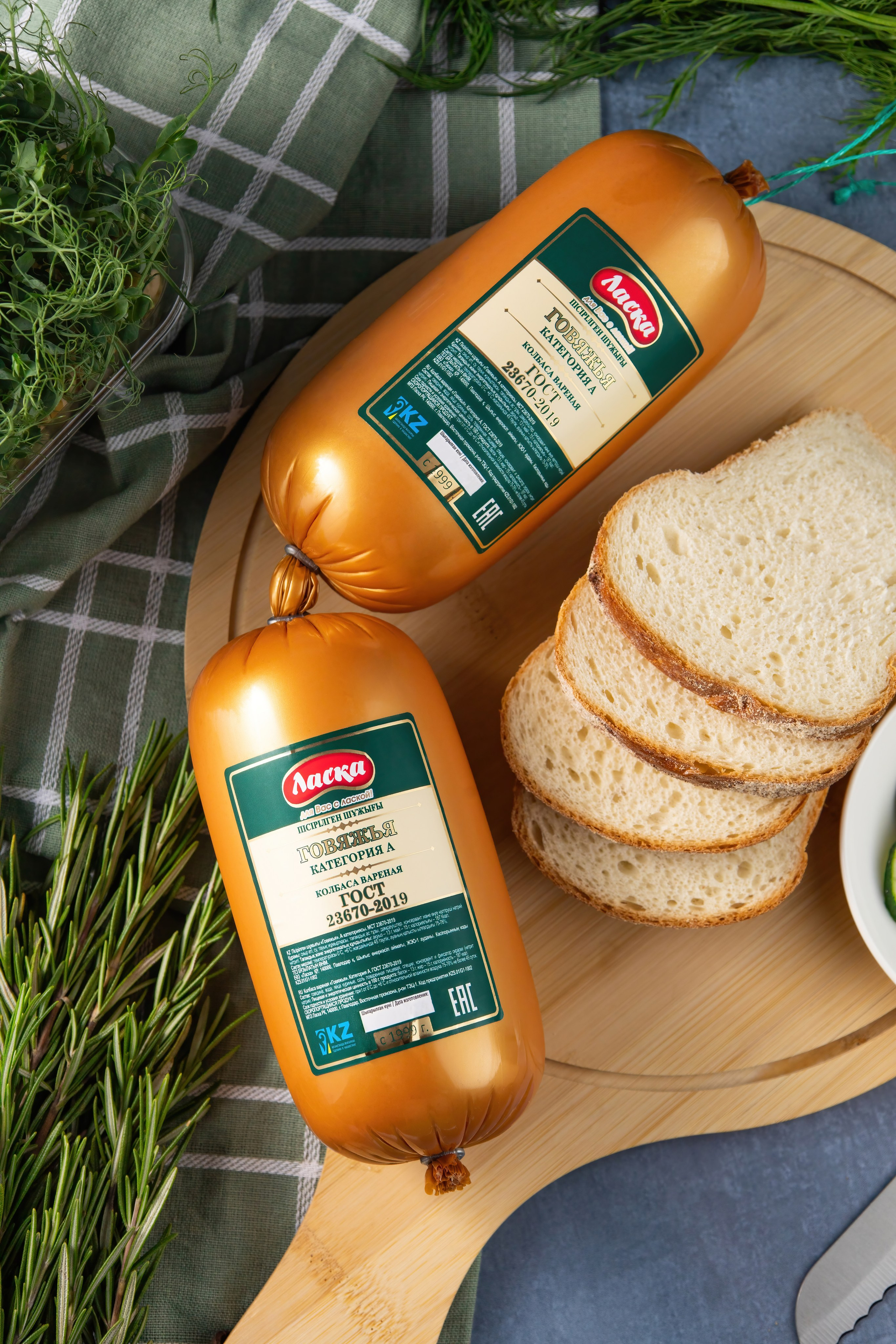 Две палки вареной колбасы на столе с продуктами