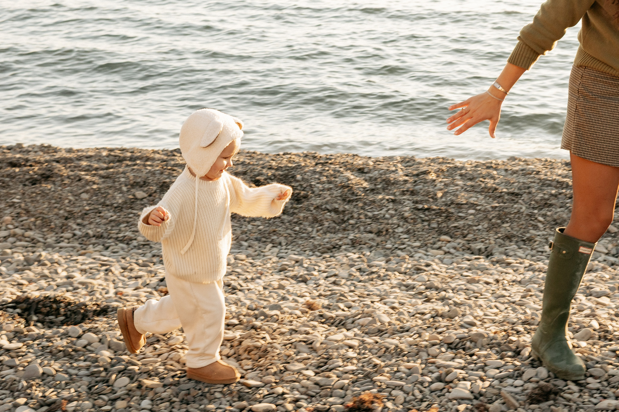 Золотой час освещает счастливые лица семьи на морском берегу