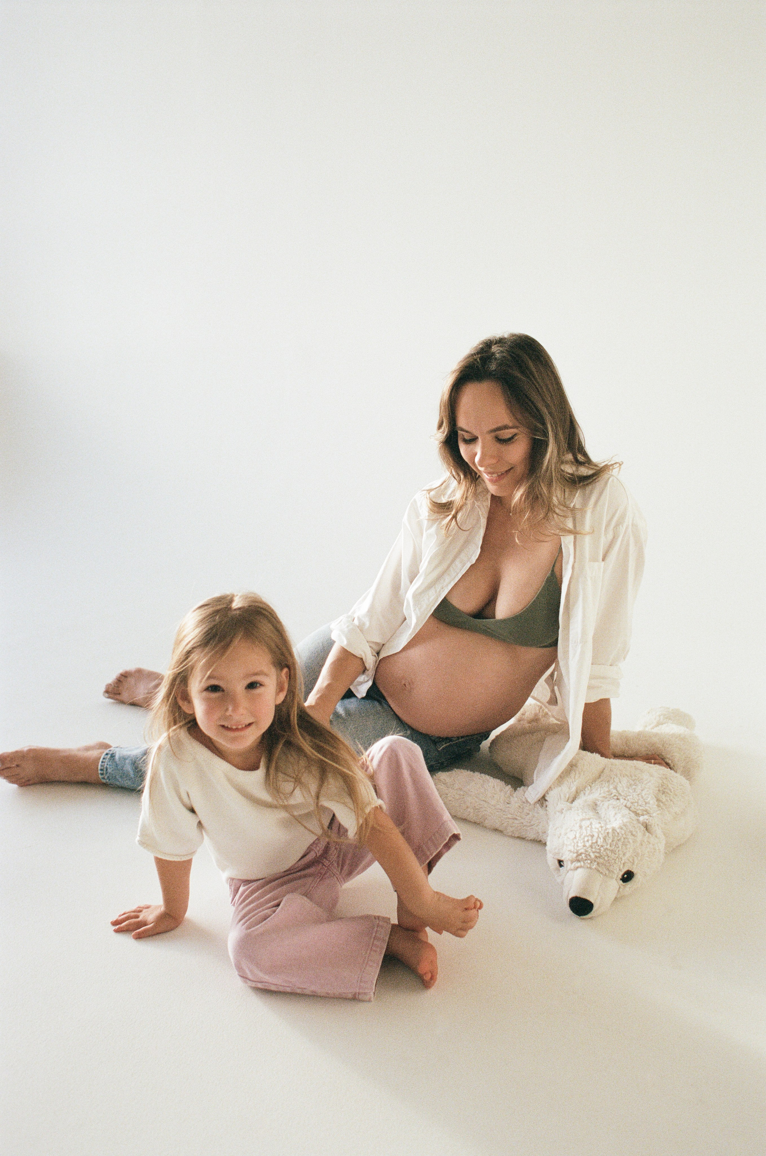 a daughter and a mother to be having fun on the floor in the studio