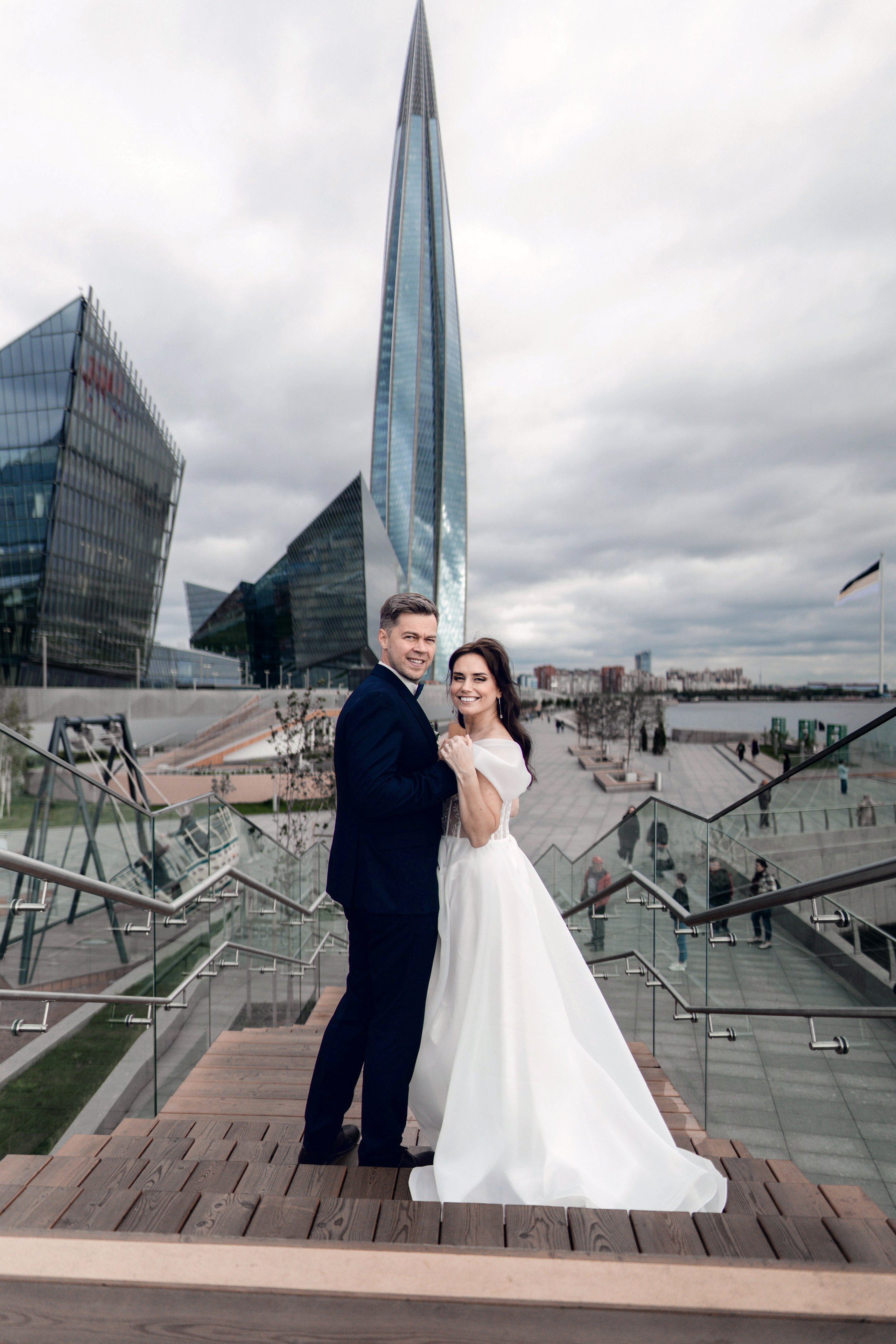 Свадебная фотосессия рядом с Лахта центром Пара стоит на смотровой площадке на фоне Лахта центра и Башни Газпром