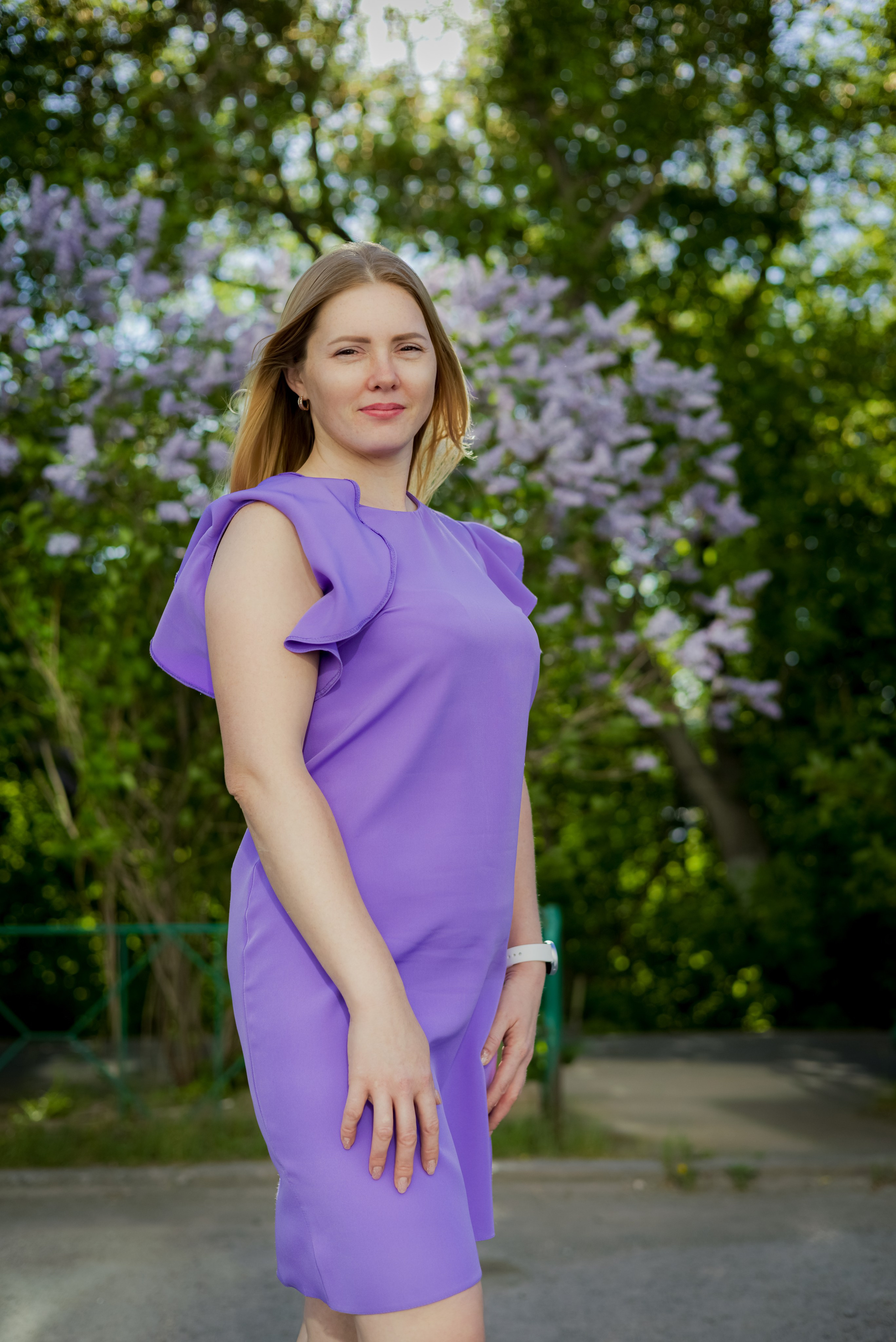 Женщина в белом платье на фоне цветущего поля и облачного неба