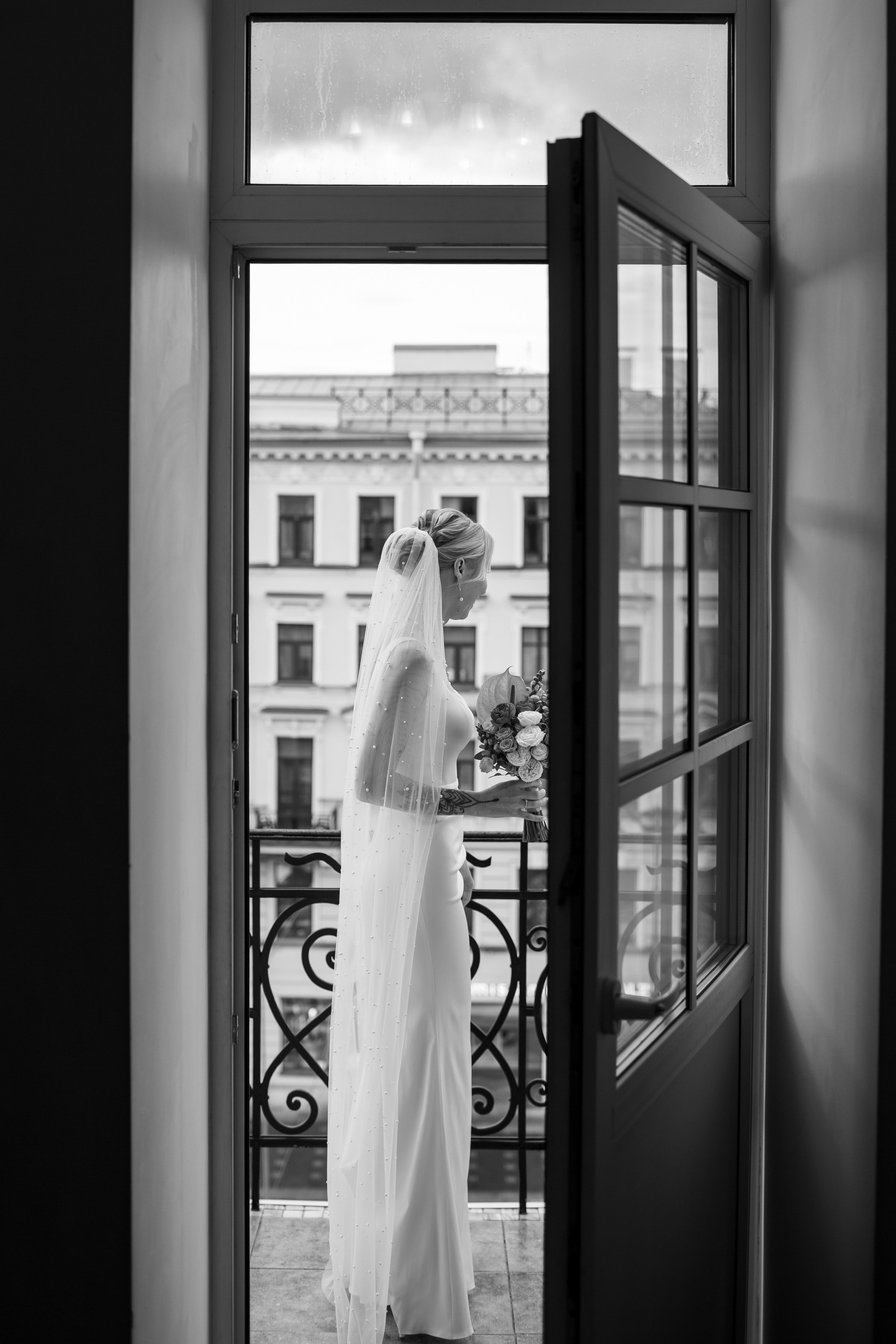 Черно-белый портрет невесты на балконе отеля в центре Петербурга.