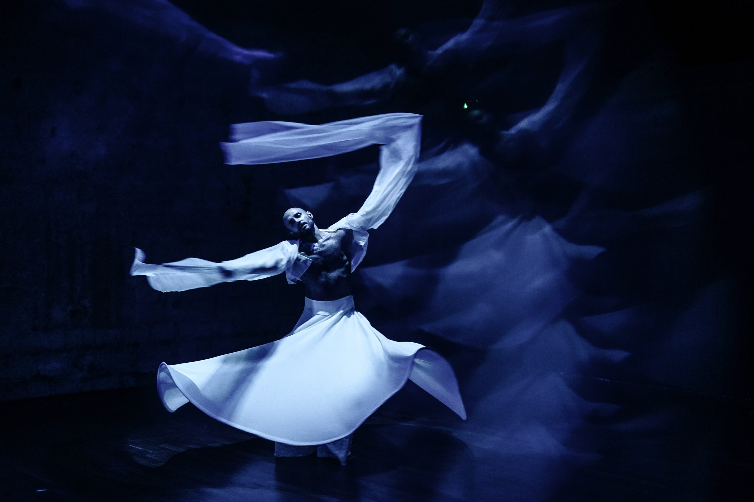 Whirling dervish dancer in white skirt in blue light, Derviche Contemporain Paris — photo by Anna Ulianova / Кружащийся дервиш в белой юбке в синем свете, Derviche Contemporain, Париж — фото Анны Ульяновой