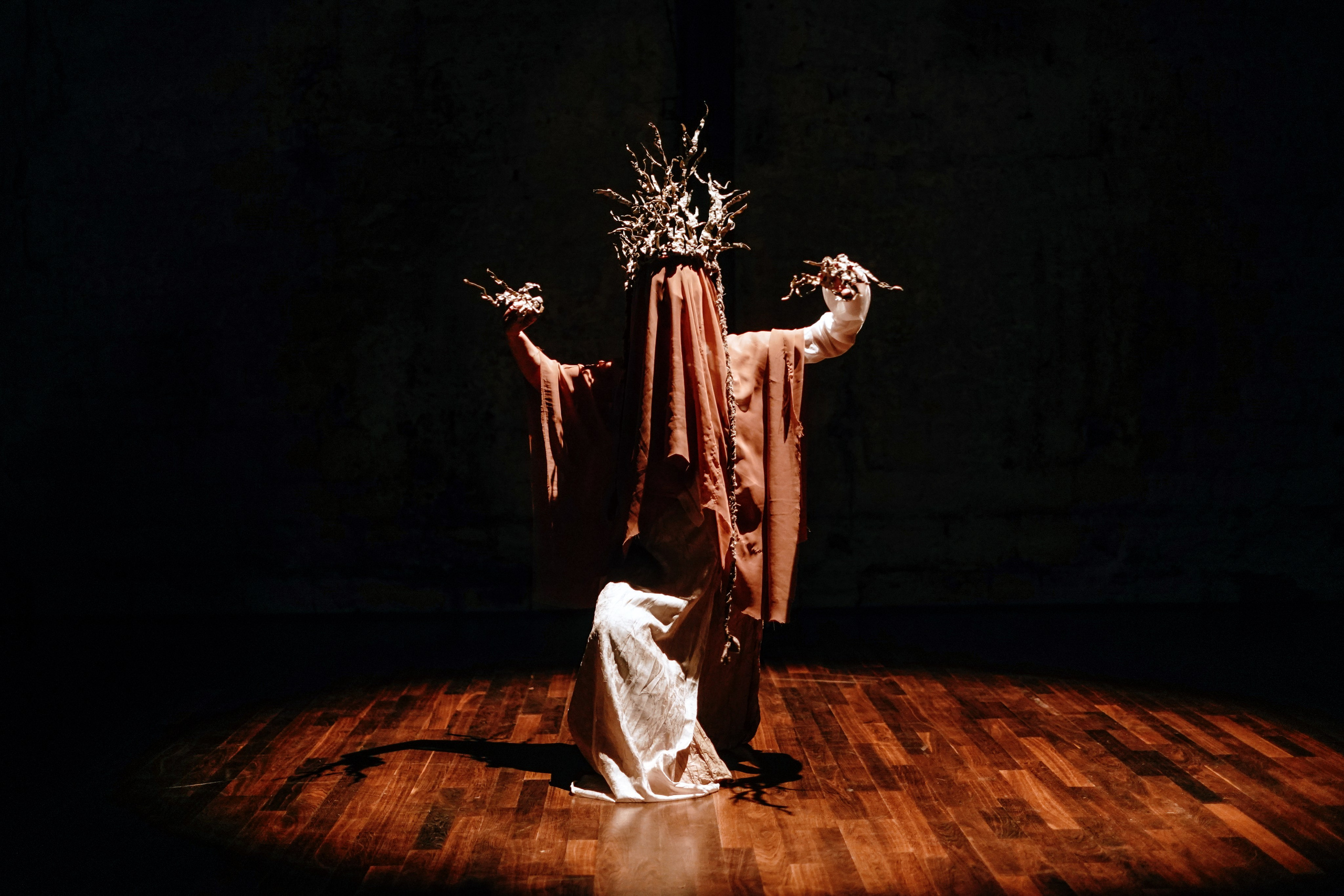 Dancer in a crown of branches kneeling on stage in warm light, Festival SOUM Paris — photo by Anna Ulianova / Танцор в короне из ветвей на коленях на сцене в тёплом свете, фестиваль SOUM, Париж — фото Анны Ульяновой