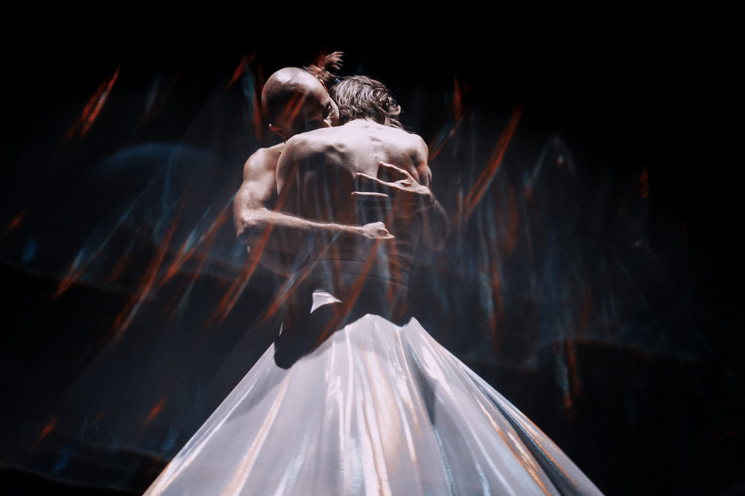 Dance photography: Nour Gebrael, contemporary dervish, performing “Androgyne” — two figures embracing in motion blur and streaks of light. Photo: Anna Ulianova