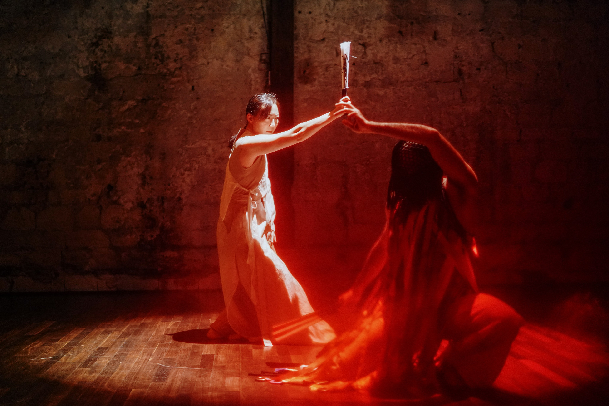 Two dancers in red light, one reaching toward the other, dance performance Paris — photo by Anna Ulianova / Два танцора в красном свете, один тянется к другому, танцевальный перфоманс, Париж — фото Анны Ульяновой