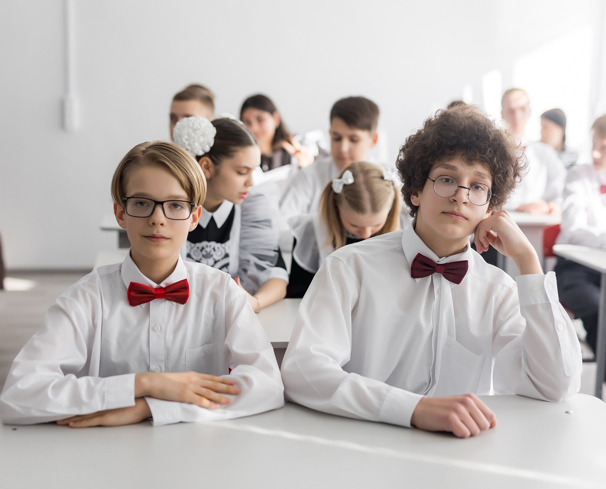 Два школьника за партой на фотосессии для выпускной фотокниги