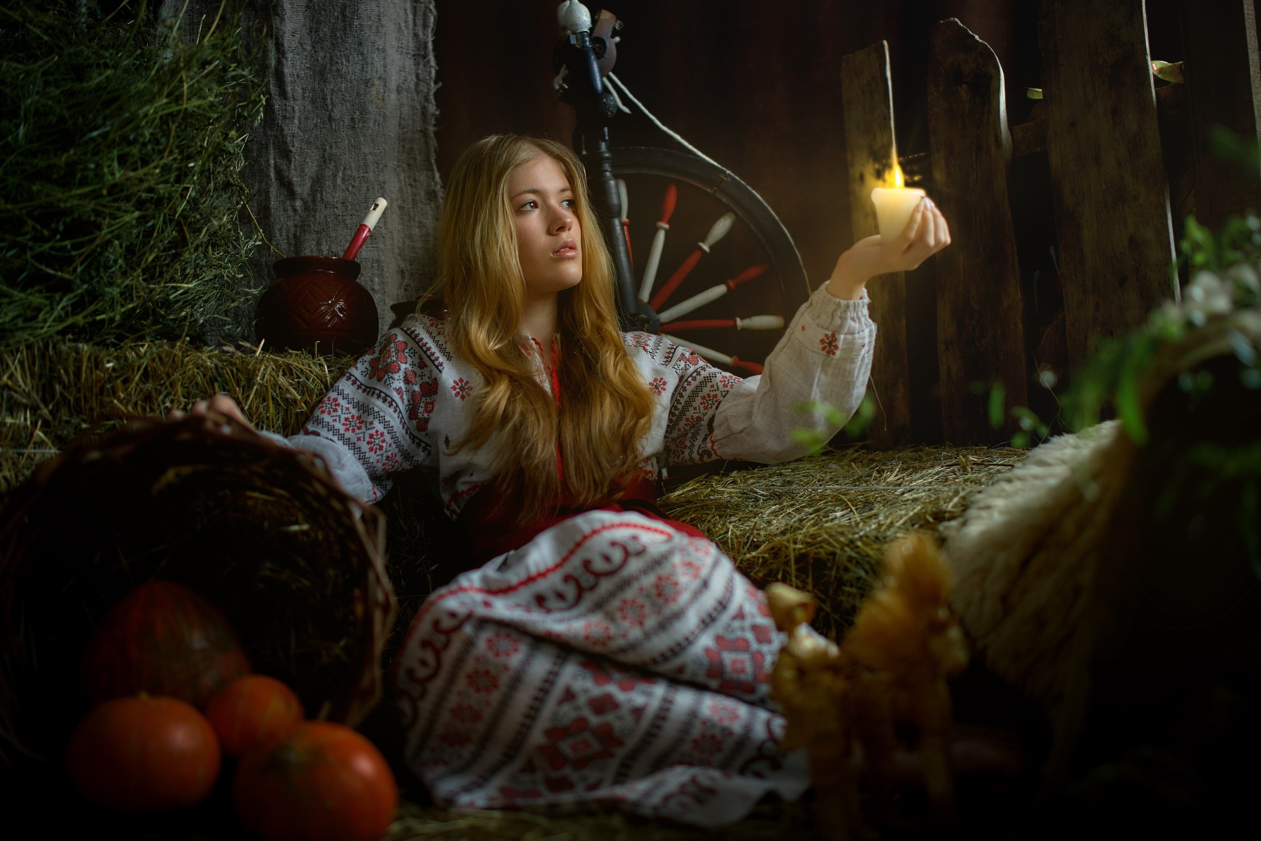 Девочка держит свечку в руках в национальном костюме