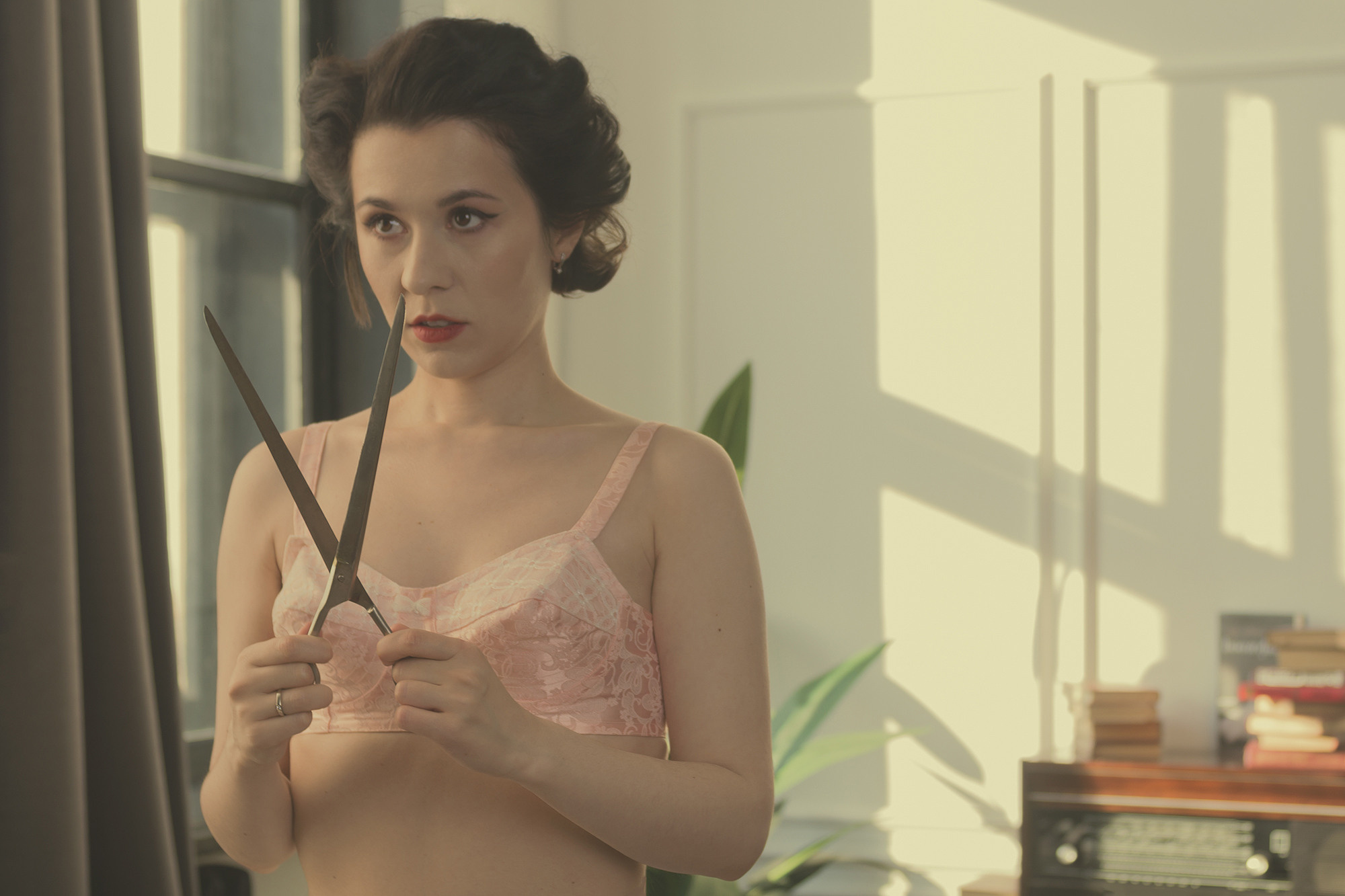 Фотография в стиле ретро. Девушка в бюстгальтере Пуля с портновскими ножницами. Винтажная тонировка.