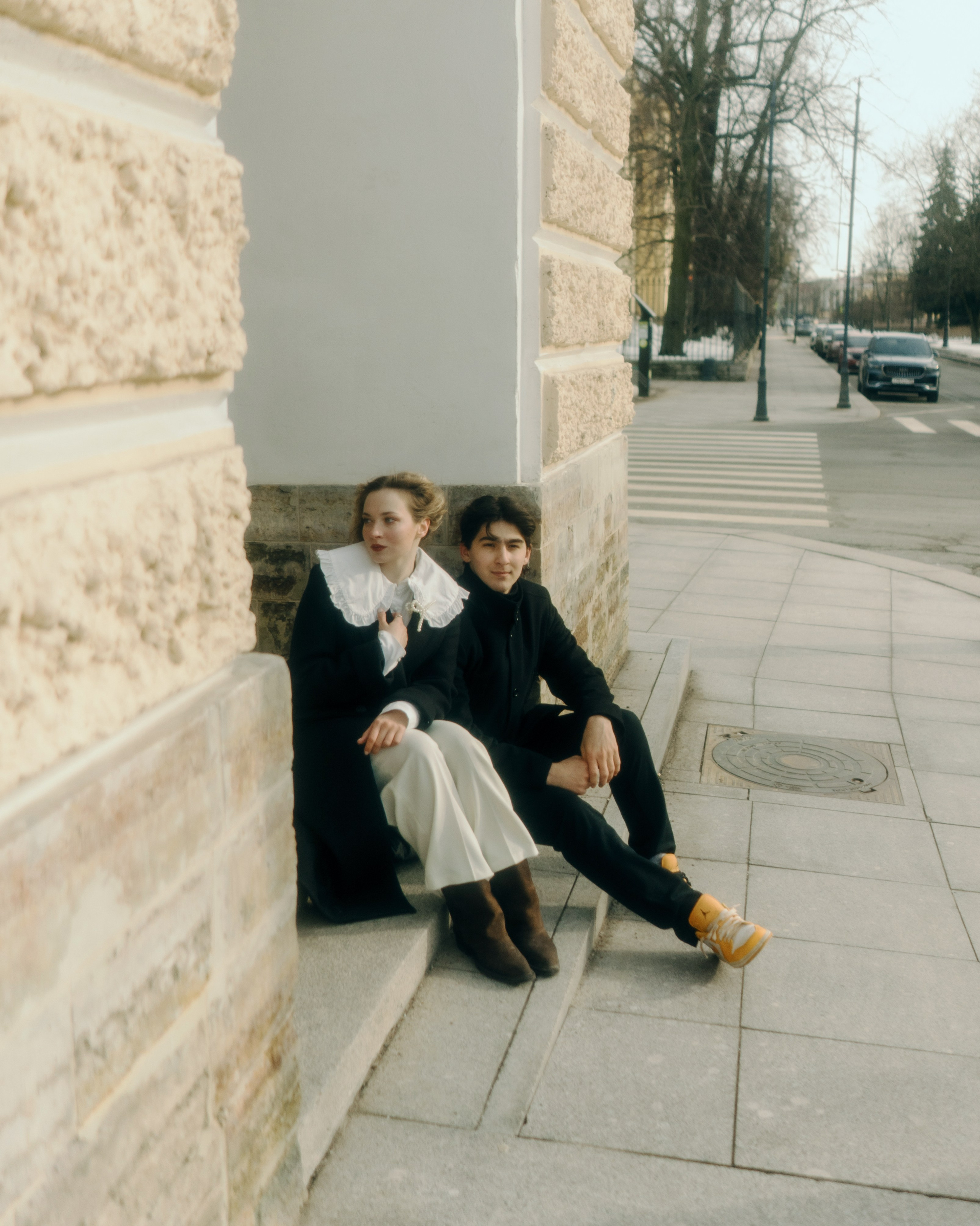 Авторская фотосессия пары у арки в Санкт-Петербурге, влюбленные сидят на ступенях, художественная love story съемка в городской эстетике в винтажном стиле