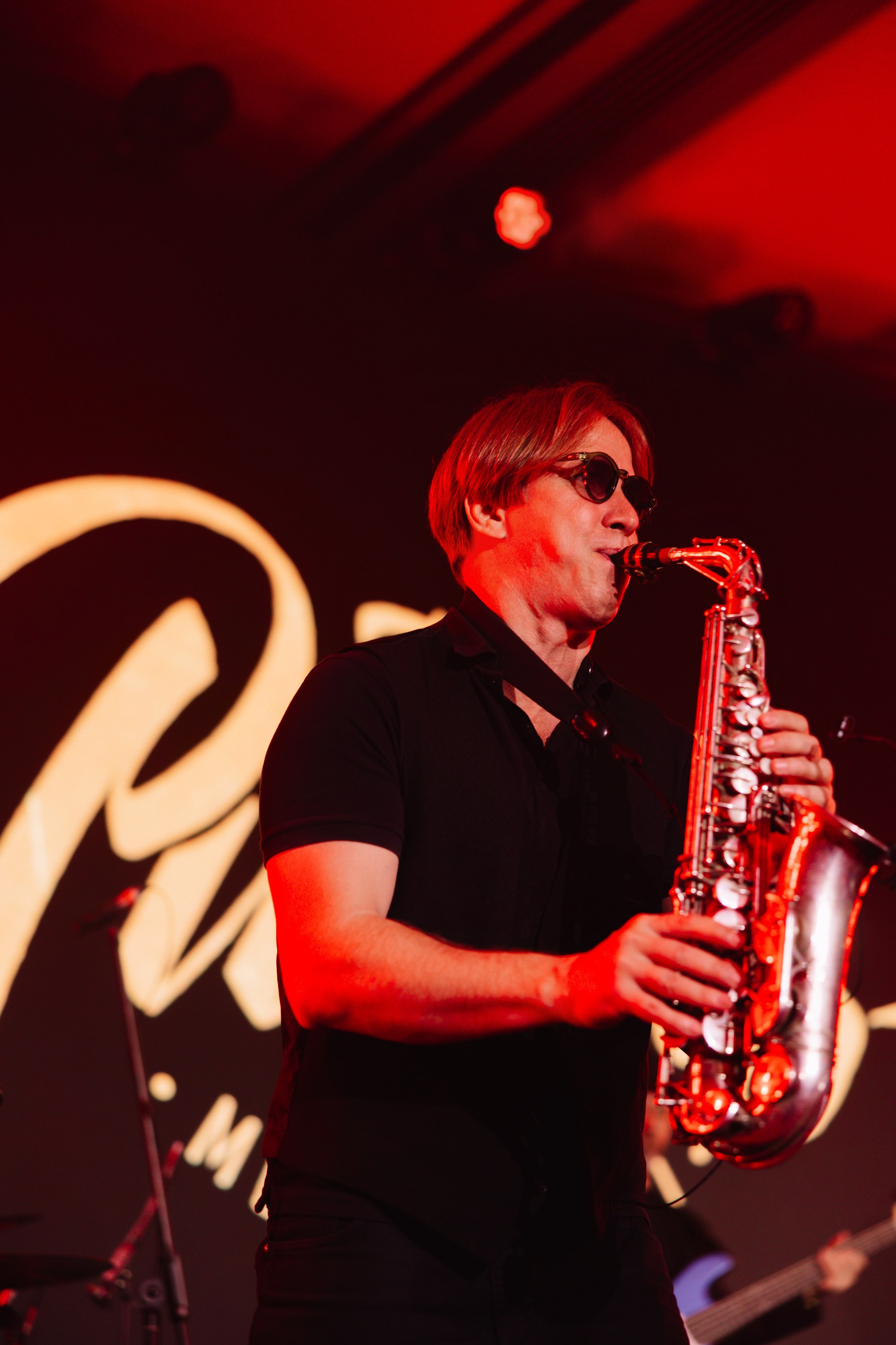 Тост: Гости поднимают бокалы с игристым вином в вечерней подсветке, момент празднования.