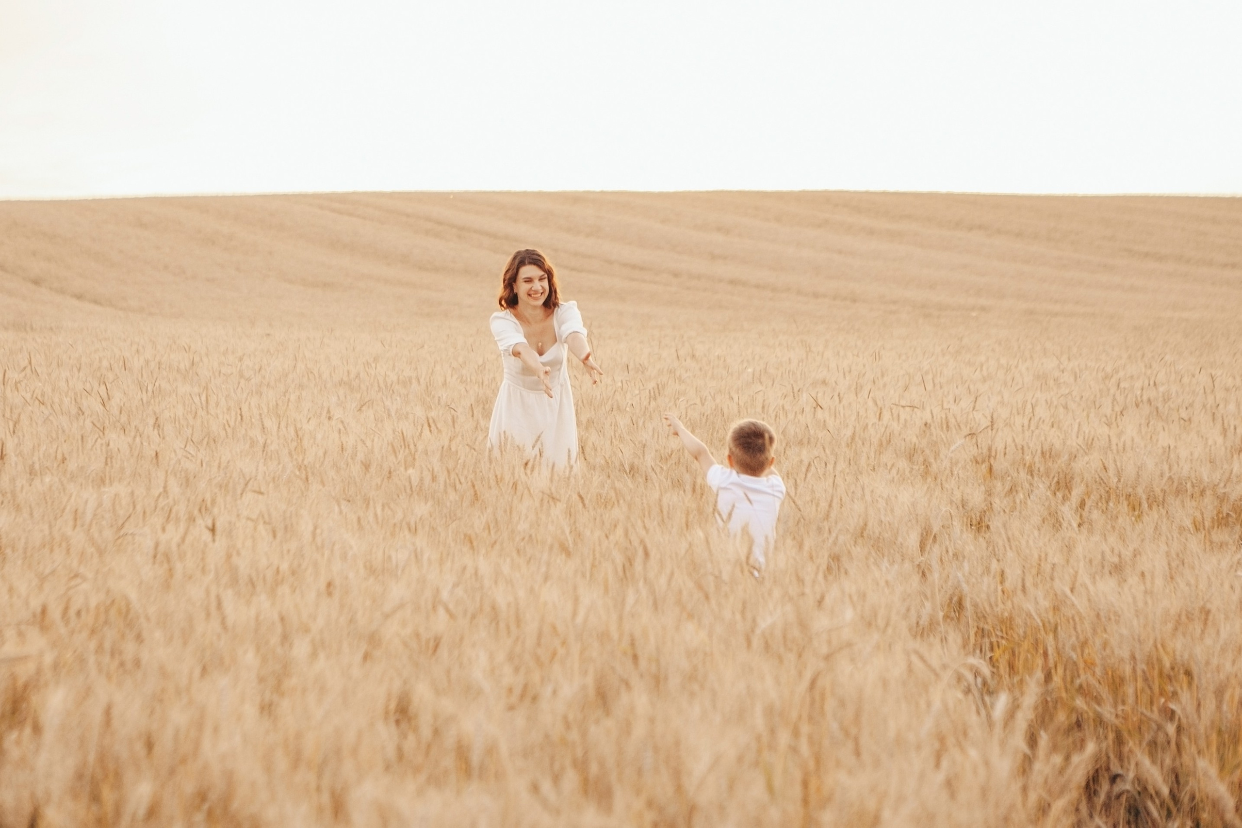мальчик бежит на руки к маме в большом поле