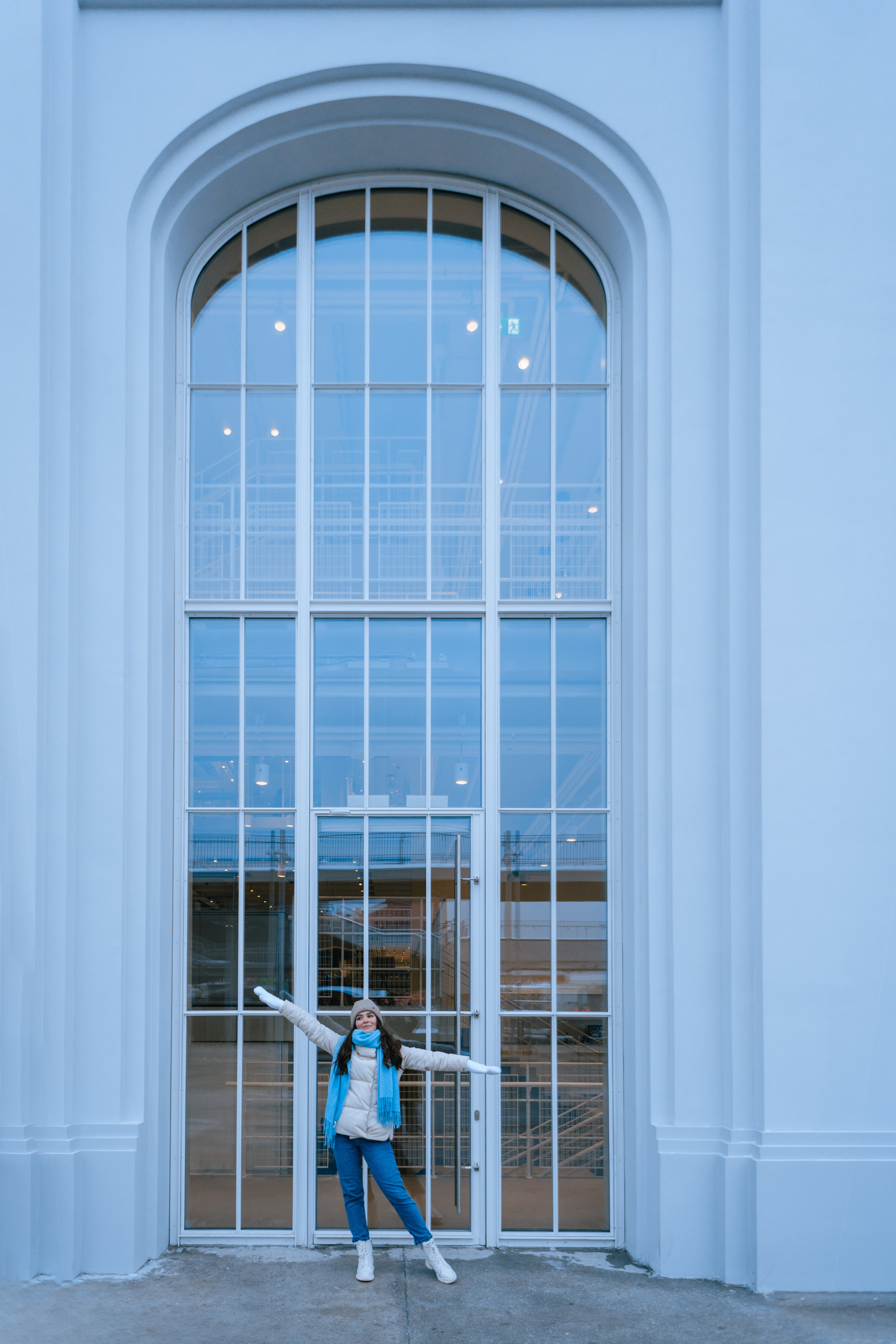 Девушка позирует у большого окна. 