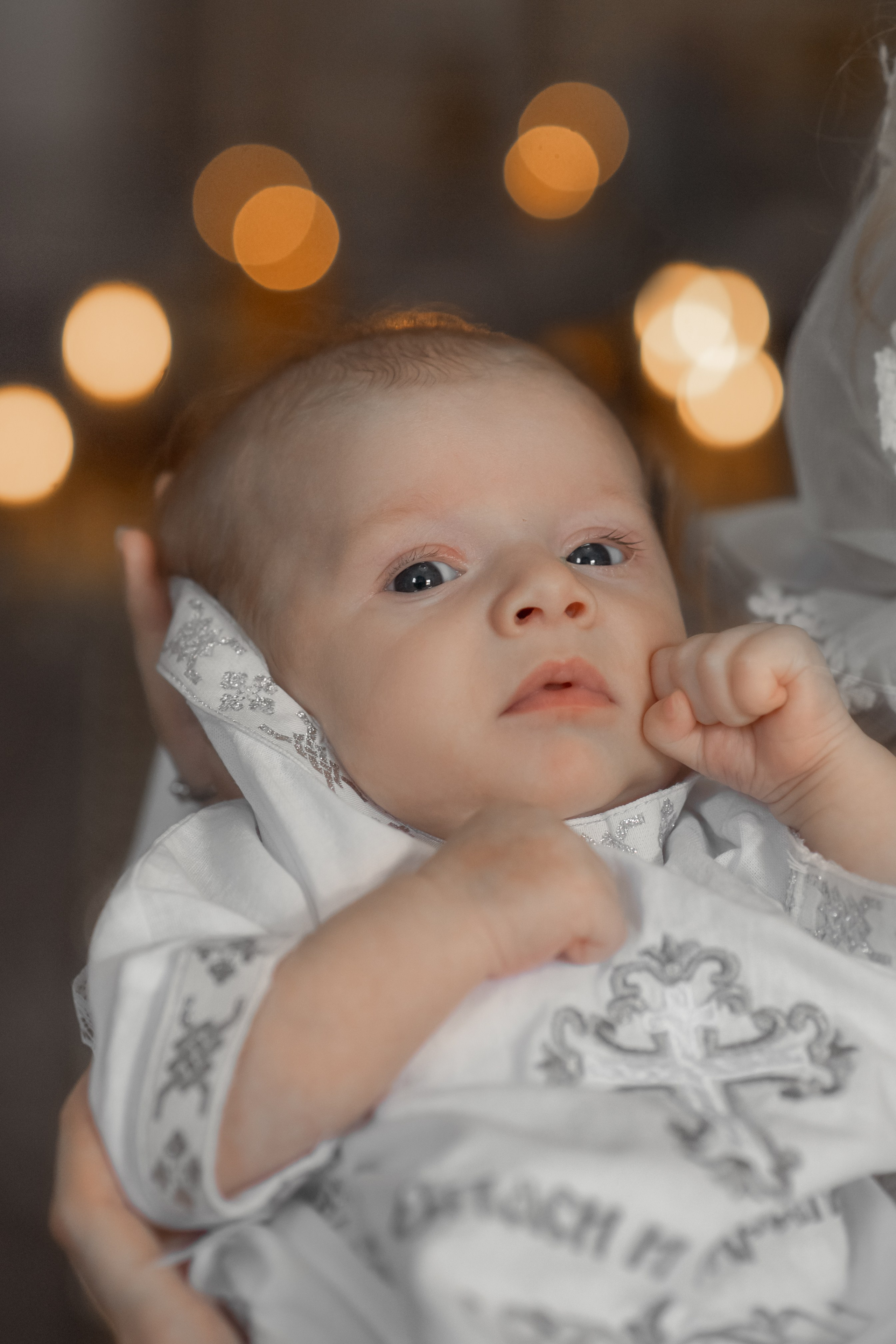 портрет малышки на крещении на фоне свечей