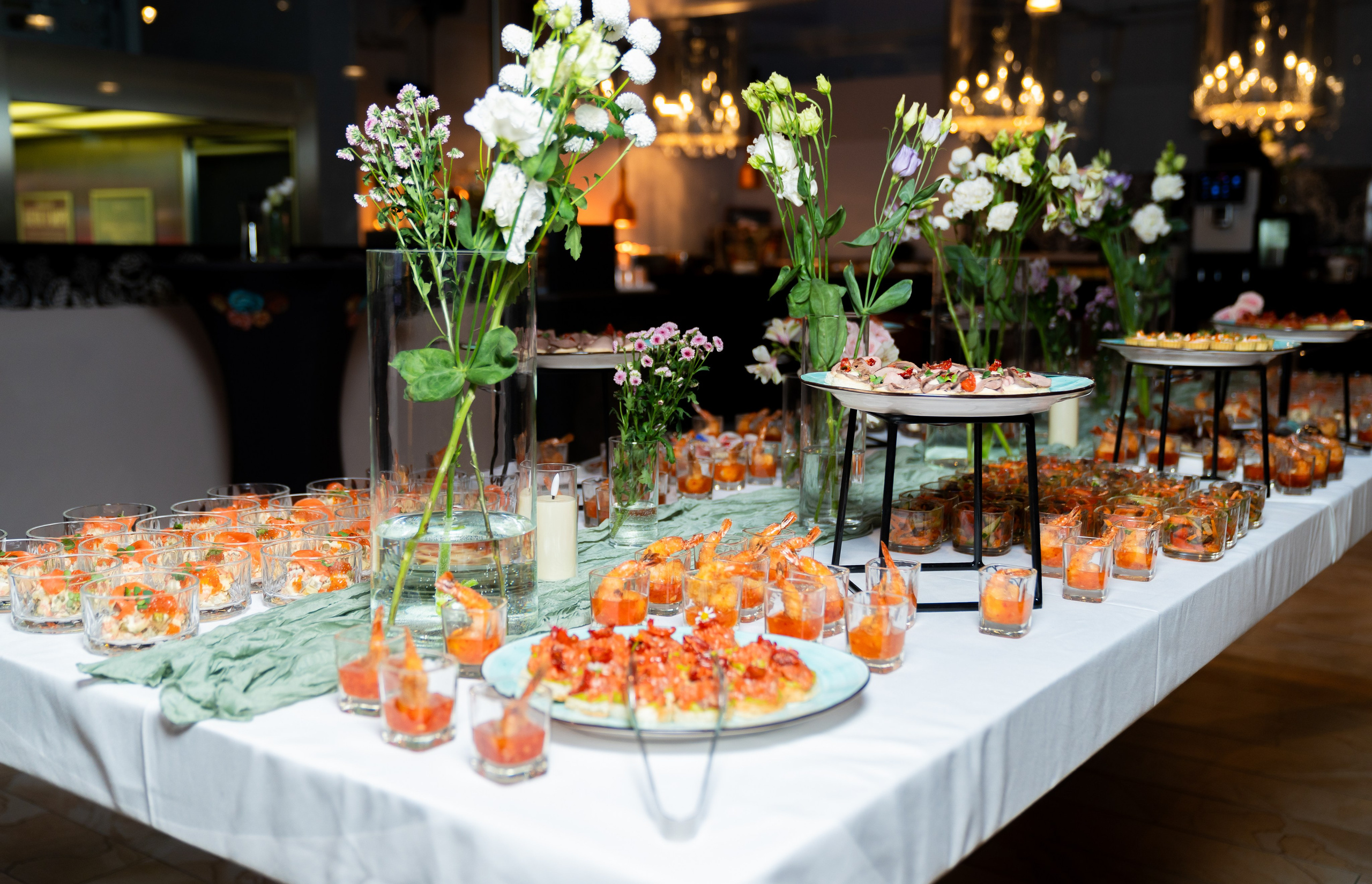 Праздничный фуршетный стол с закусками, креветками и живыми цветами в банкетном зале. Фото Евгения Мальцева, Radisson Sonya Hotel.