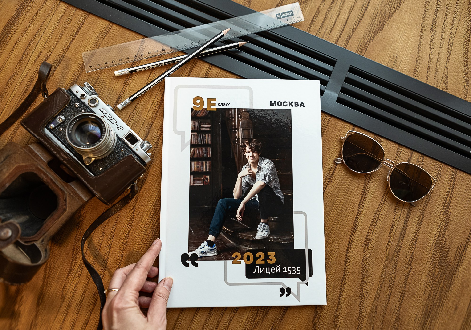 Рука держит выпускной альбом