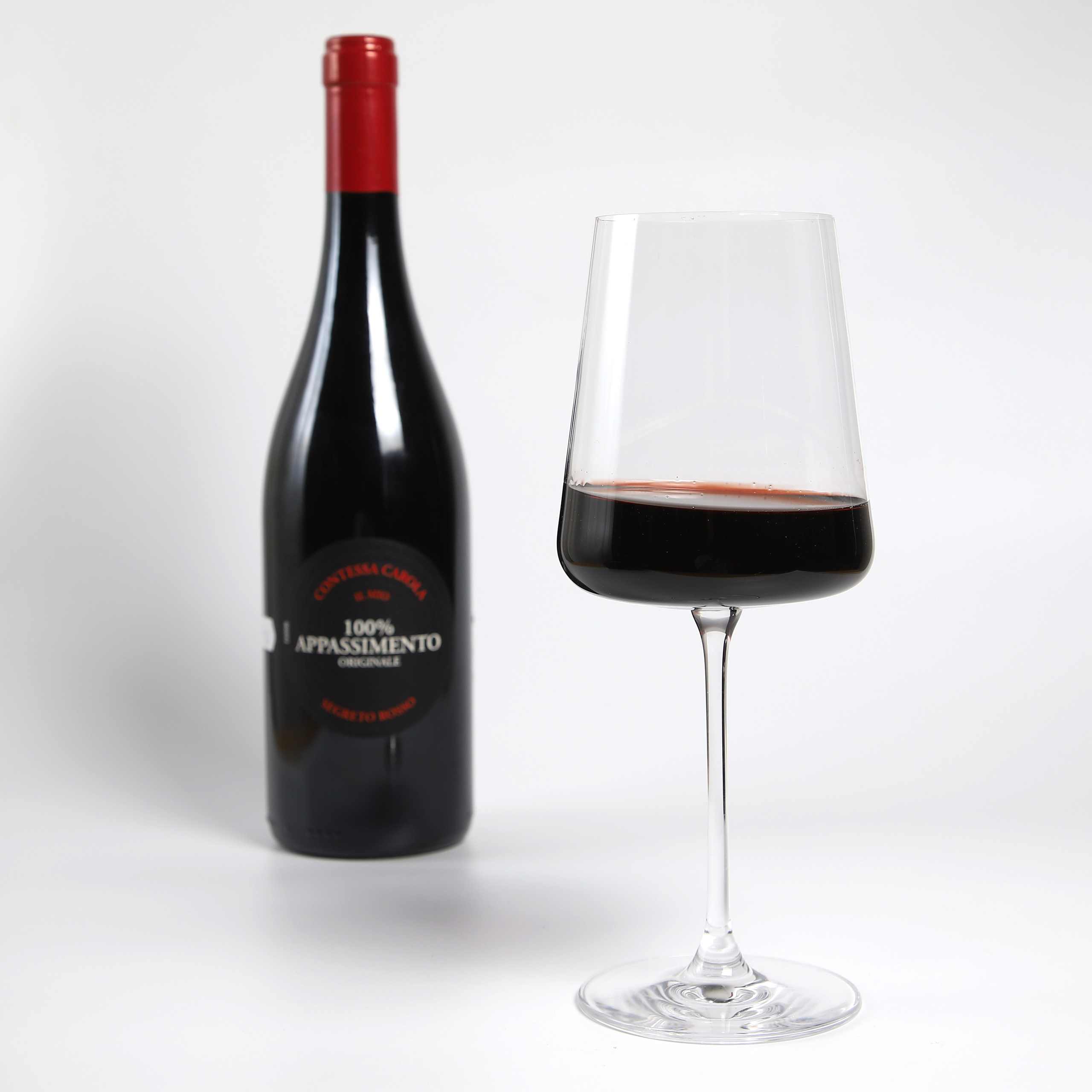 Фуд-фотография красного вина с этикеткой и бокала.