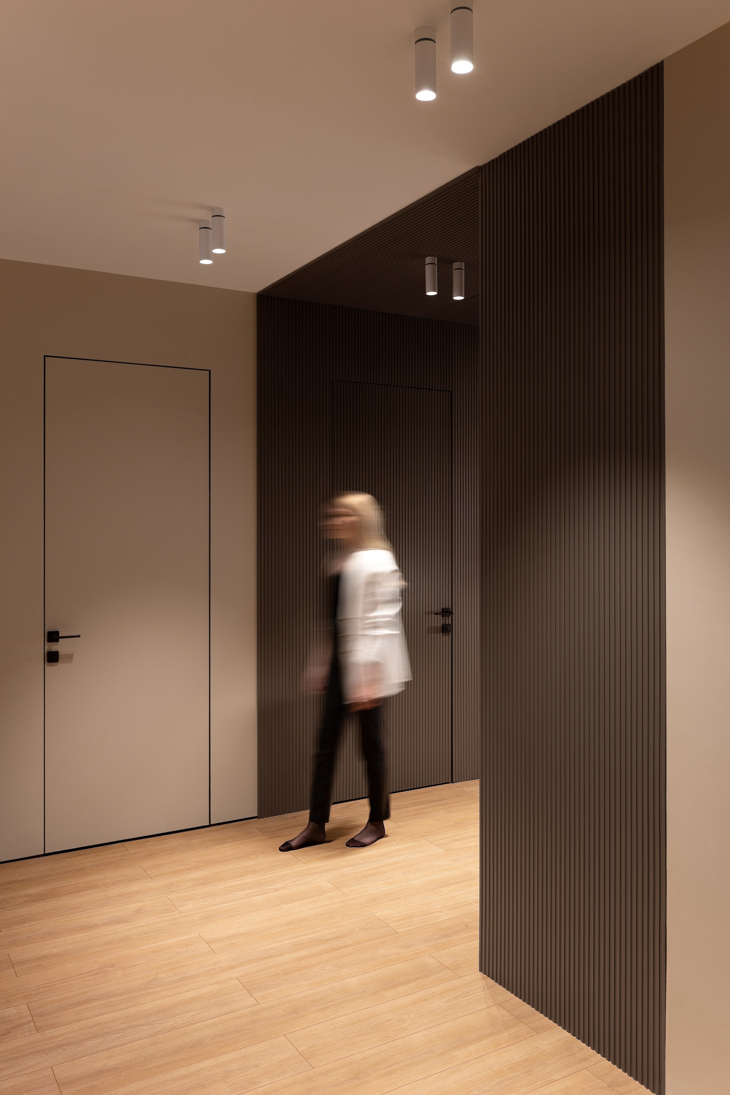 интерьер коридора с рифлеными панелями из дерева в темном цвете 