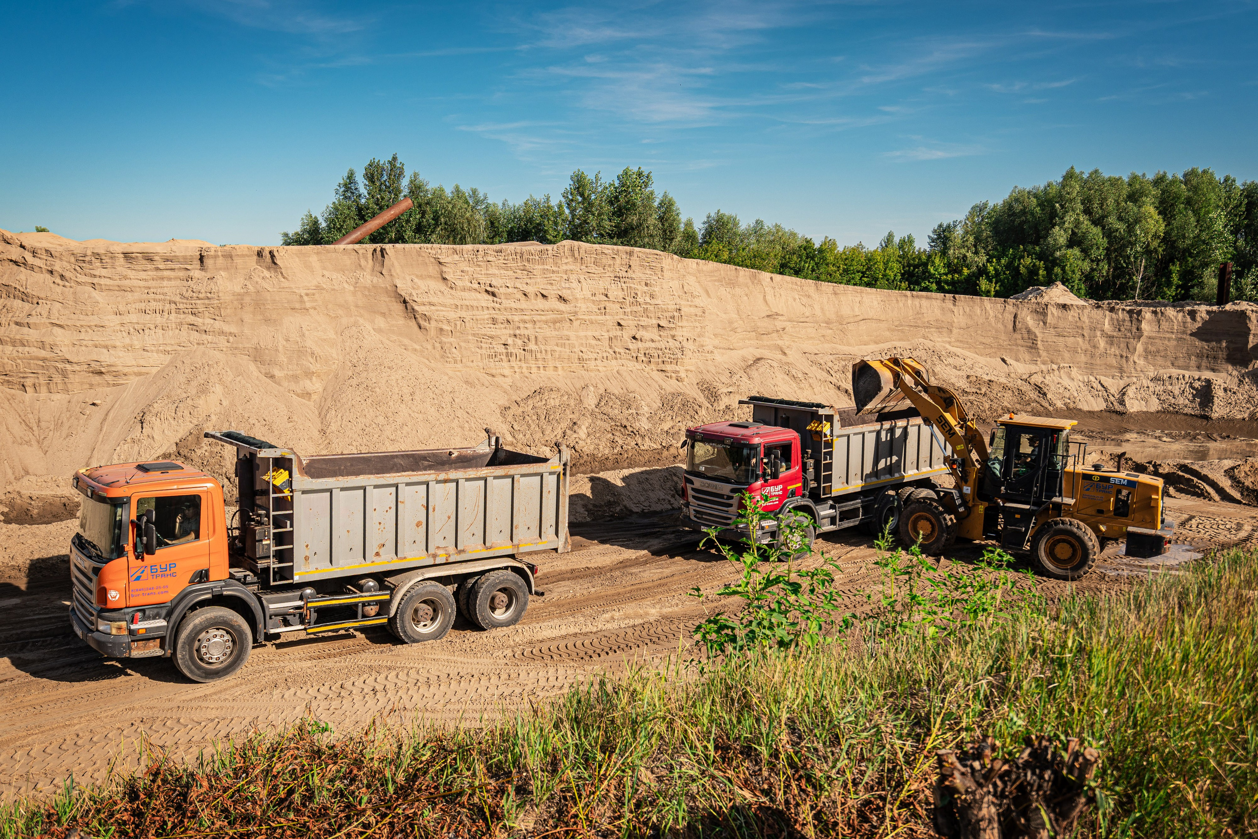 Погрузка песка в самосвал для доставки на строительный объект