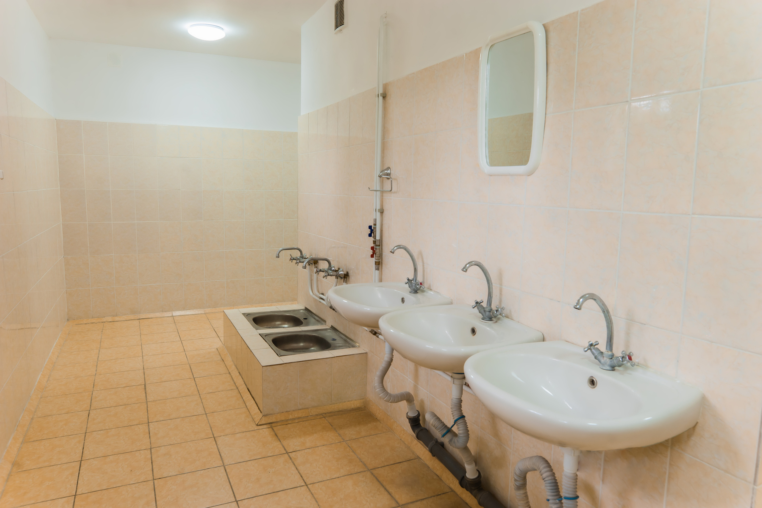 Санузел в жилом корпусе, раковины, место для мытья ног, зеркало на стене