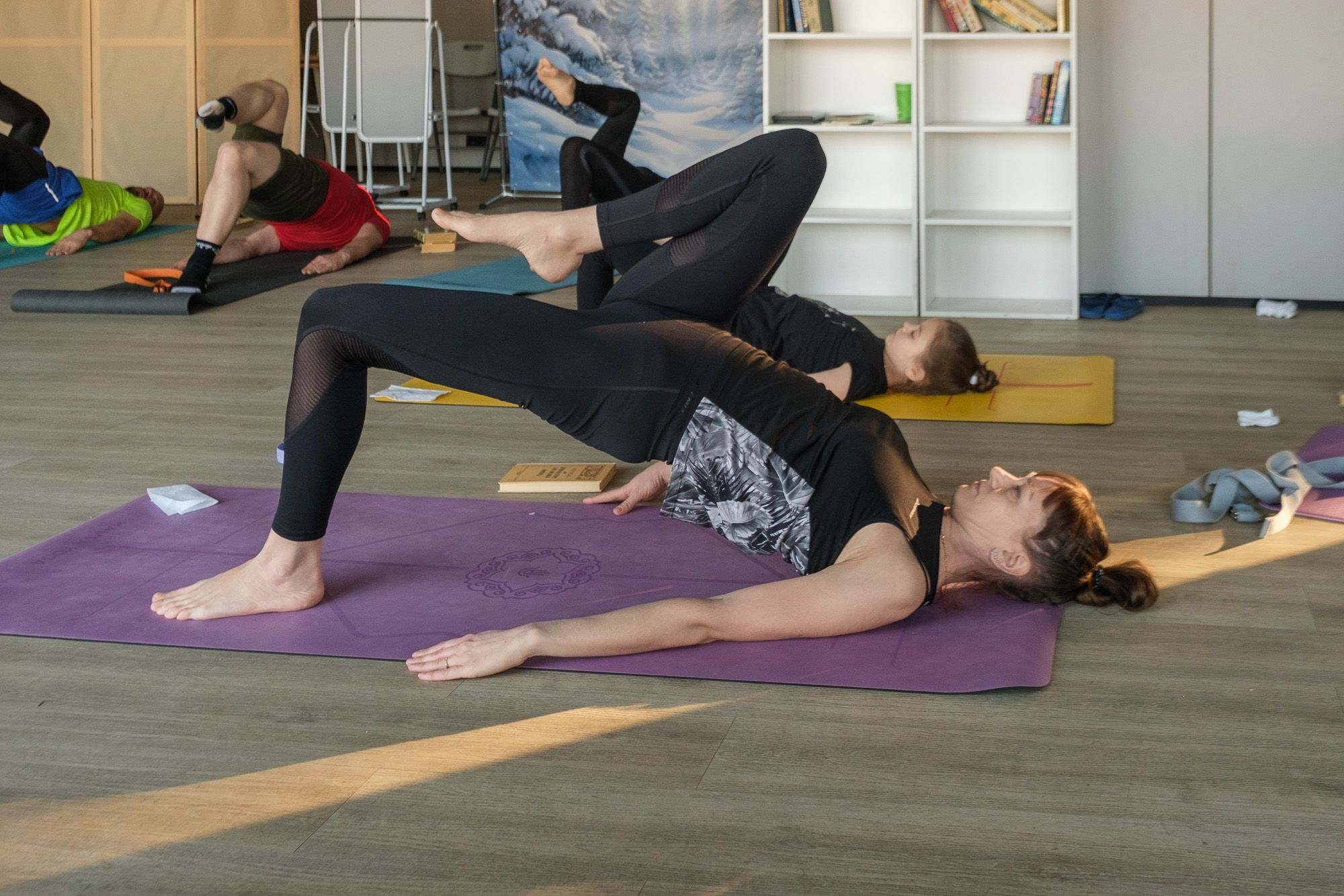 занятие по Йоге со Светланой Банакиной. Люди в зале выполняют ассану.