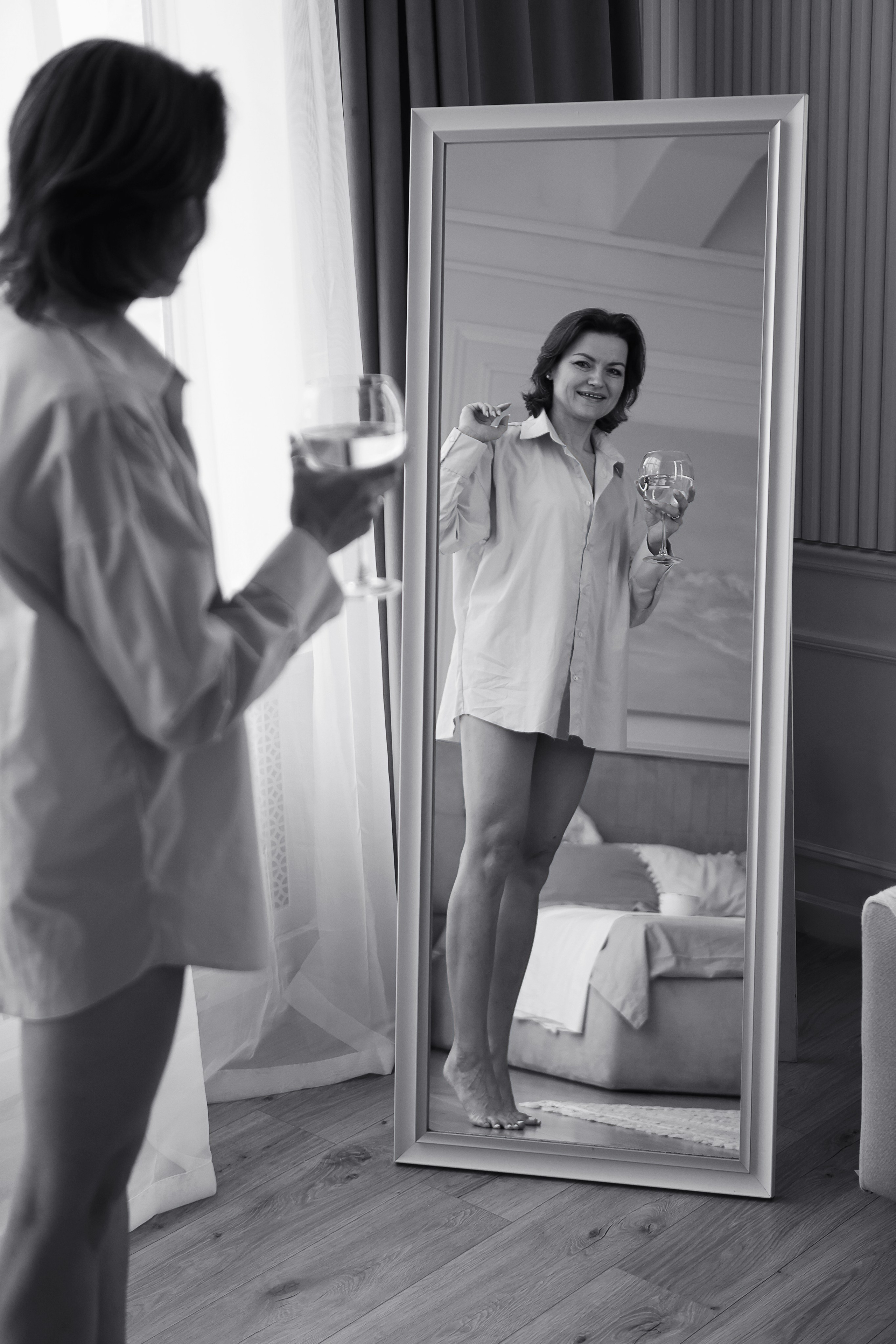 Красивая девушка смотрит на свое отражение в зеркале