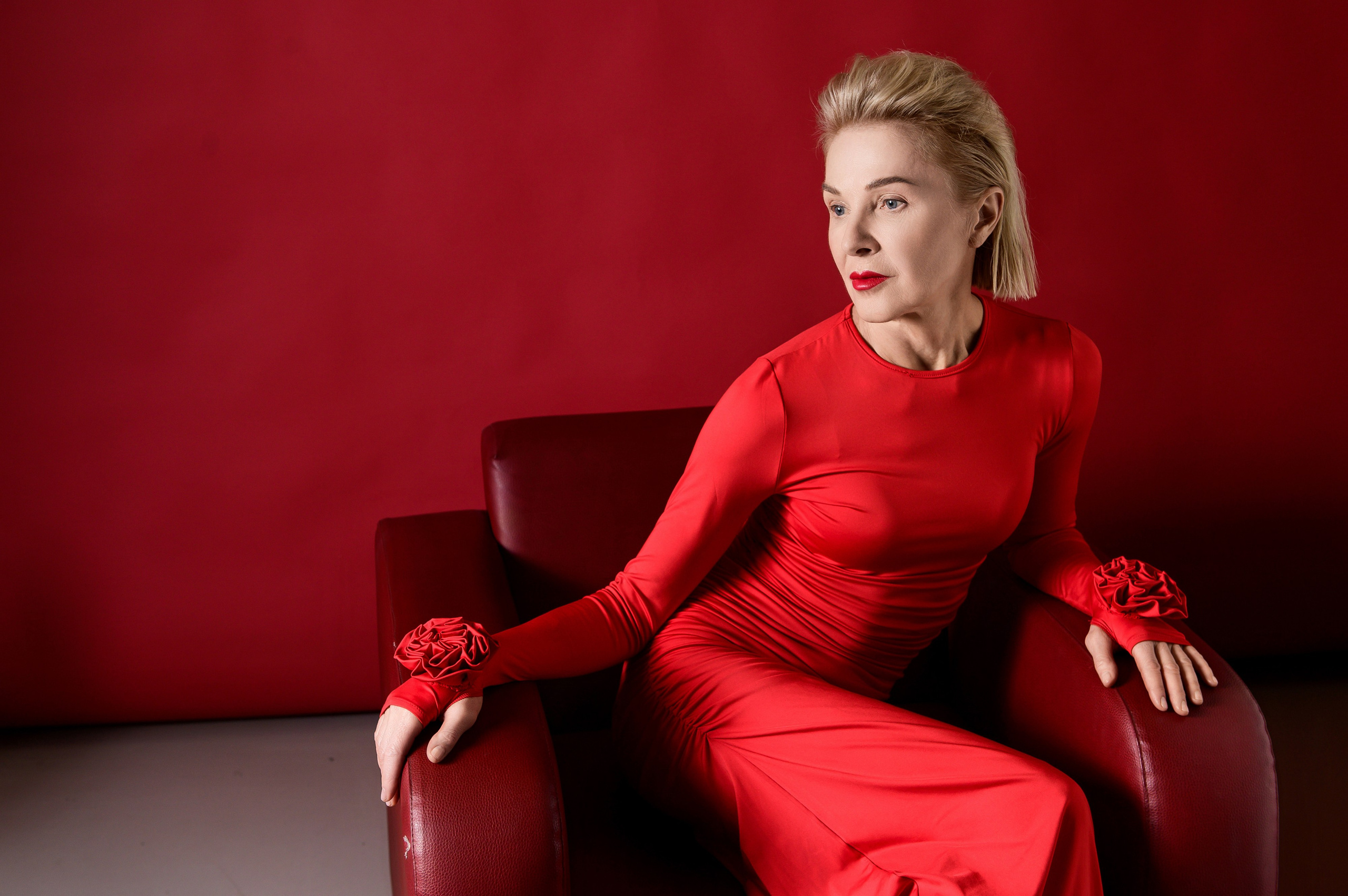 Студийная модная фотосессия в Москве — модель в красном образе в кресле на красном фоне