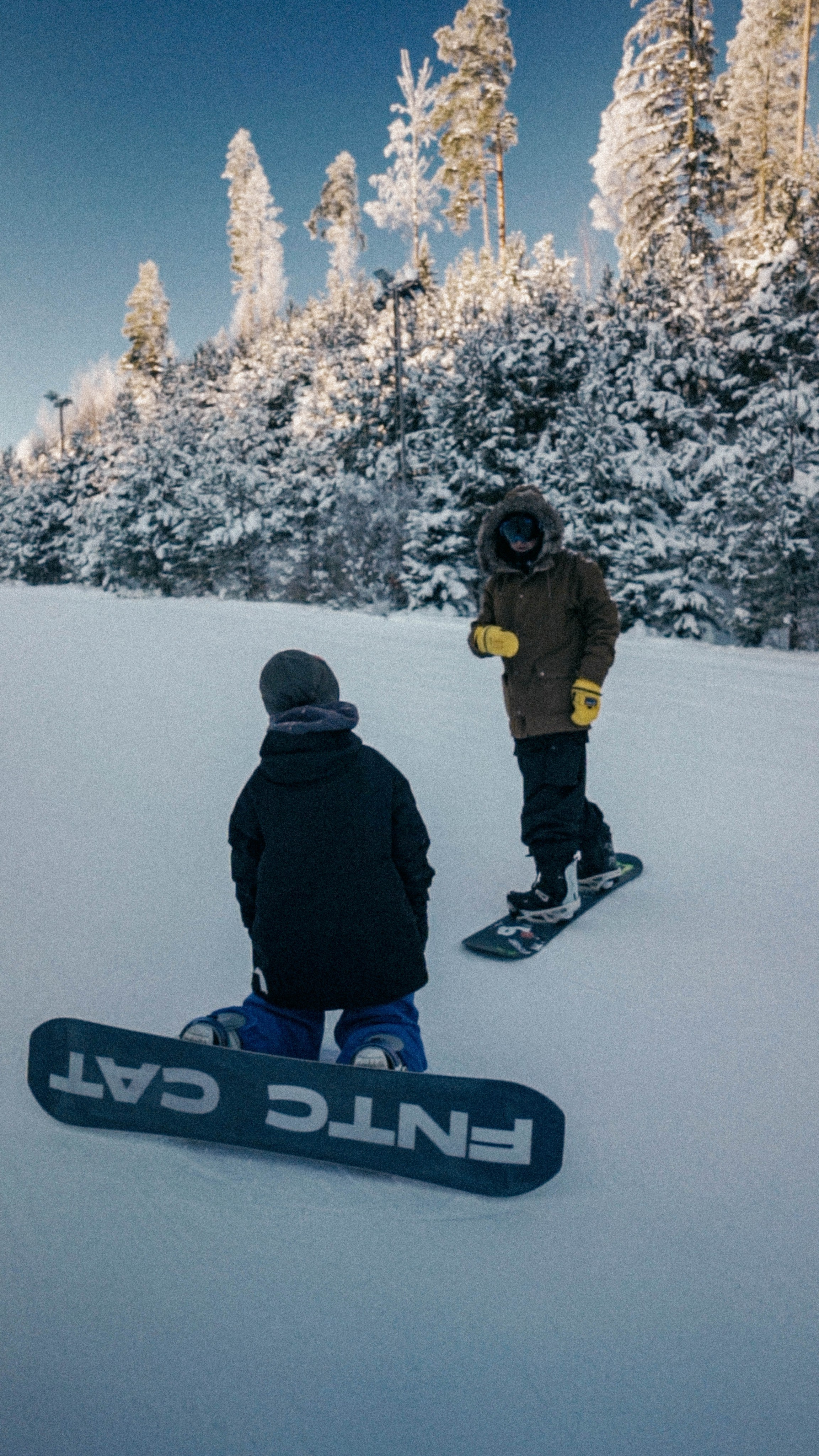 Тренер по сноуборду объясняет спортсмену выполнение фристайл трюка