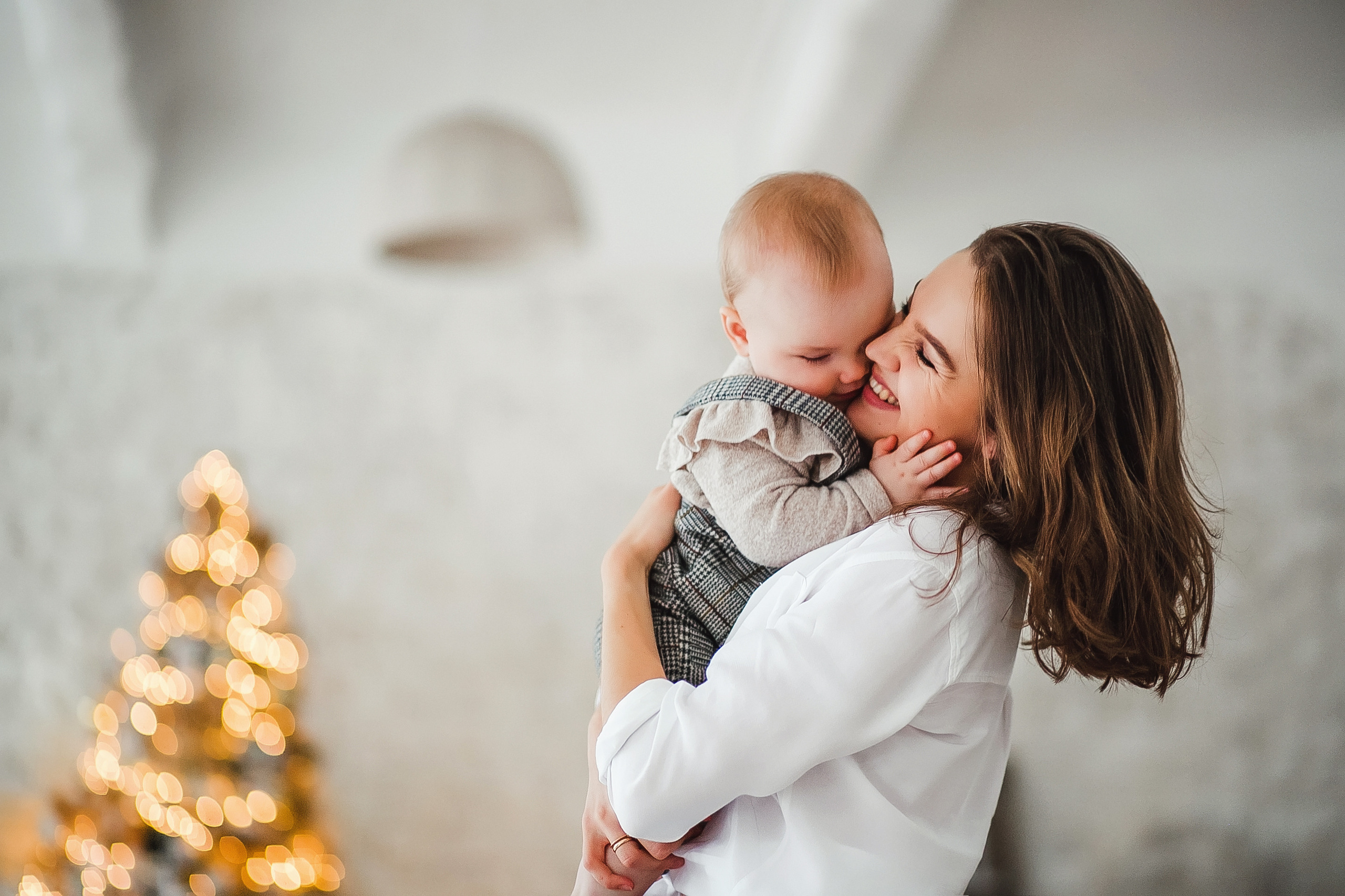 Новогодняя семейная фотосессия в студии возле елки с огоньками мама с дочкой