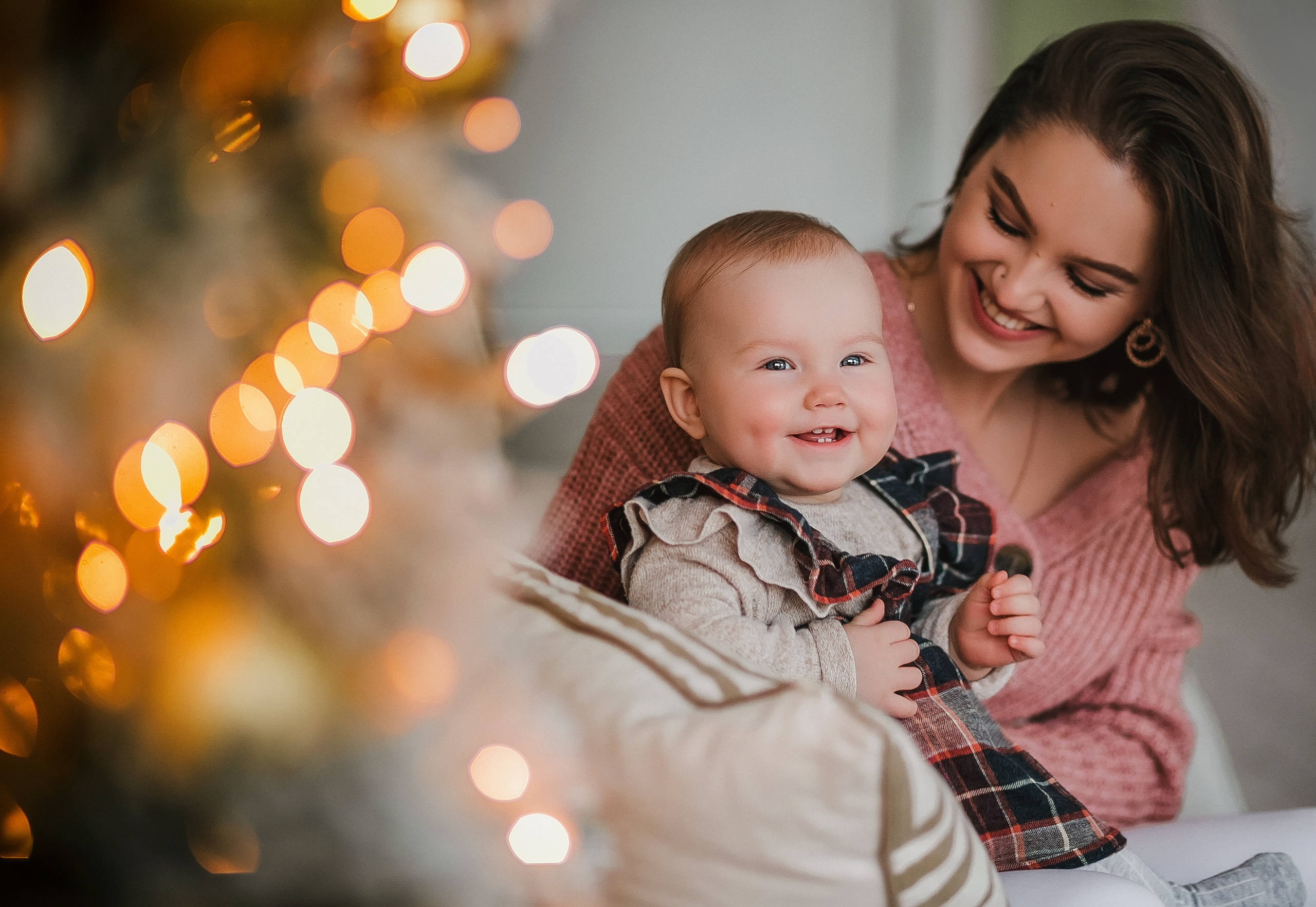 Новогодняя семейная фотосессия в студии на диване мама с малышом
