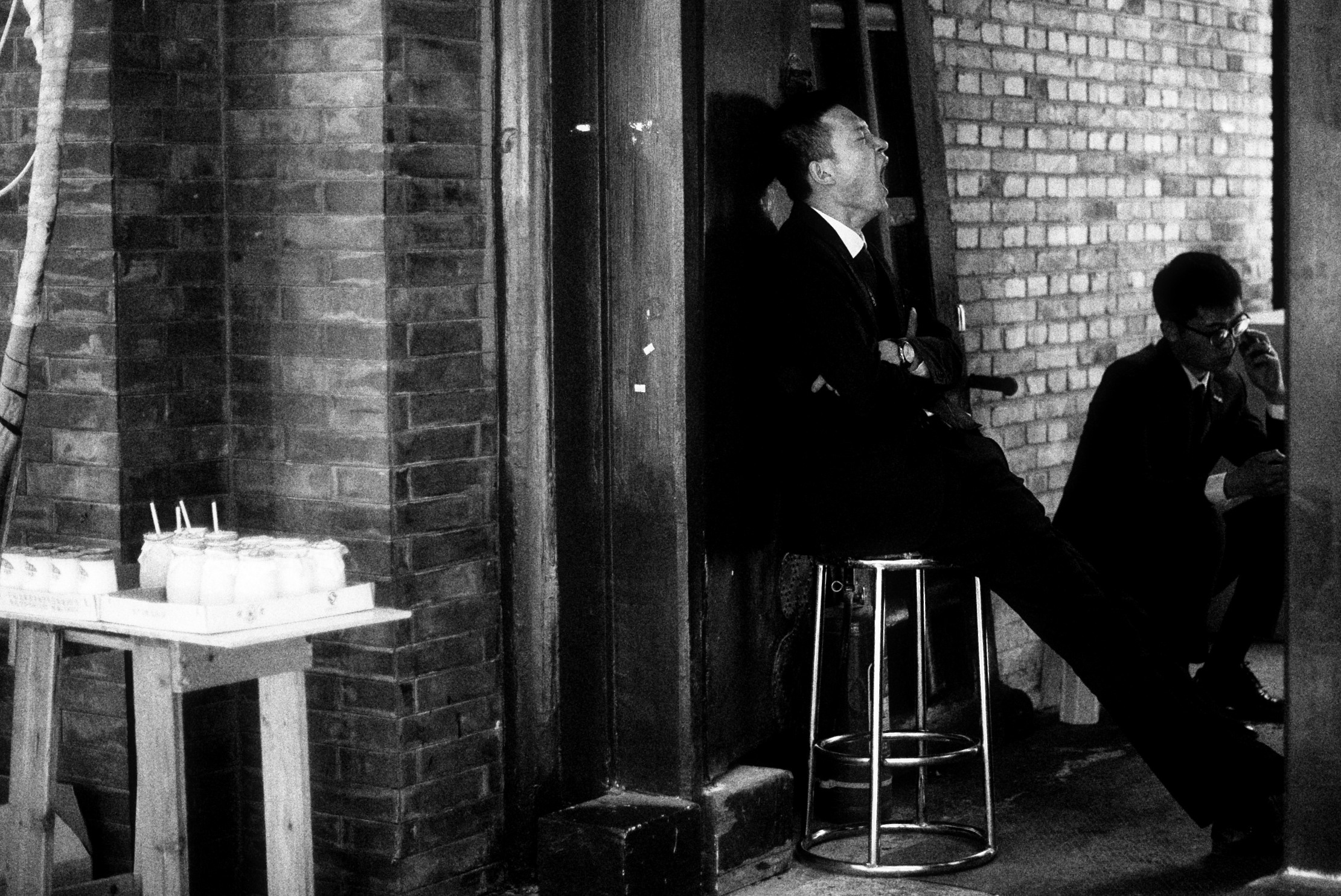 Уставший мужчина сидит на стуле на улице и зевает