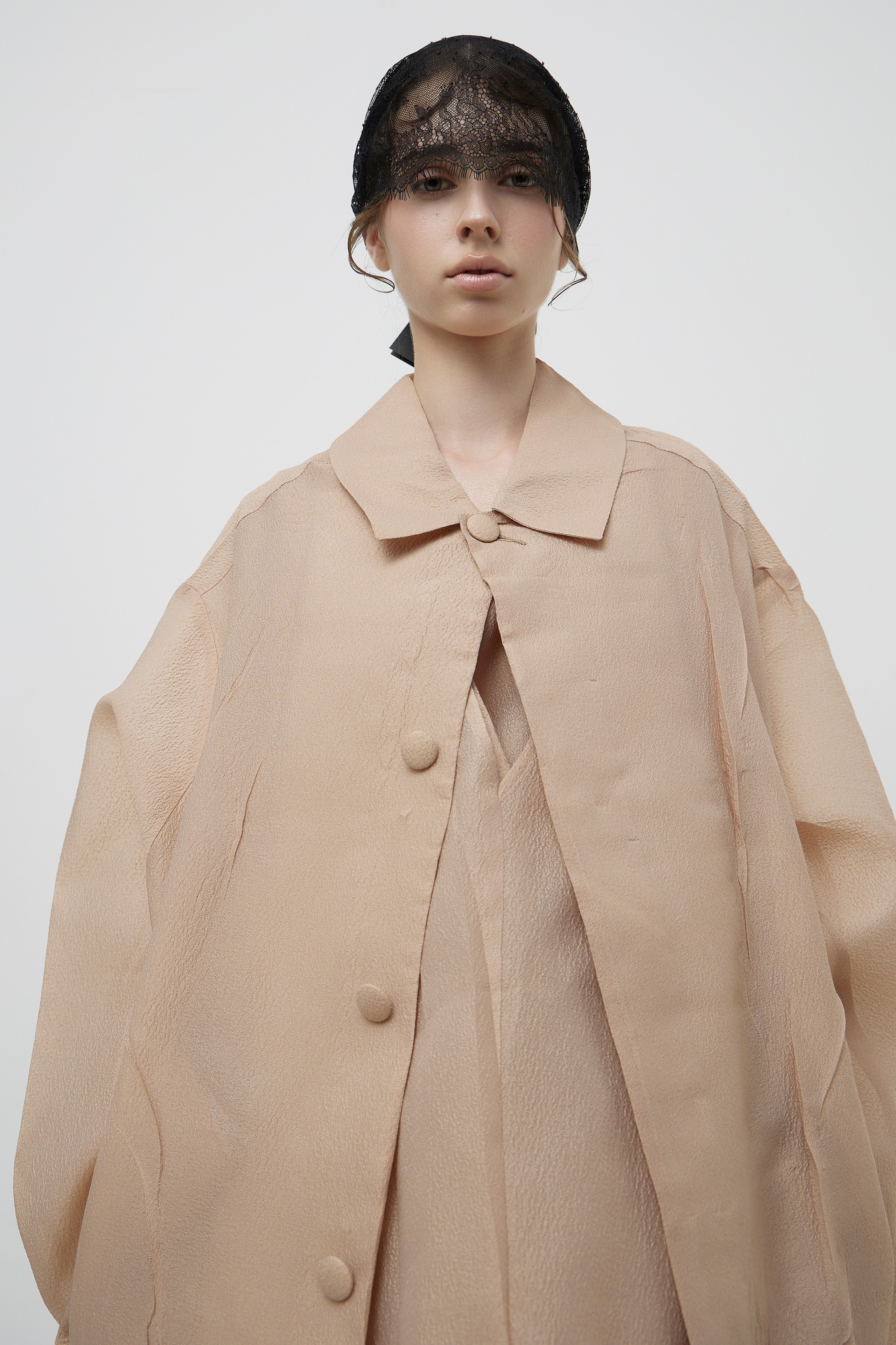 Studio fashion campaign portrait of model wearing contemporary beige designer garment photographed for fashion brand imagery in Sydney