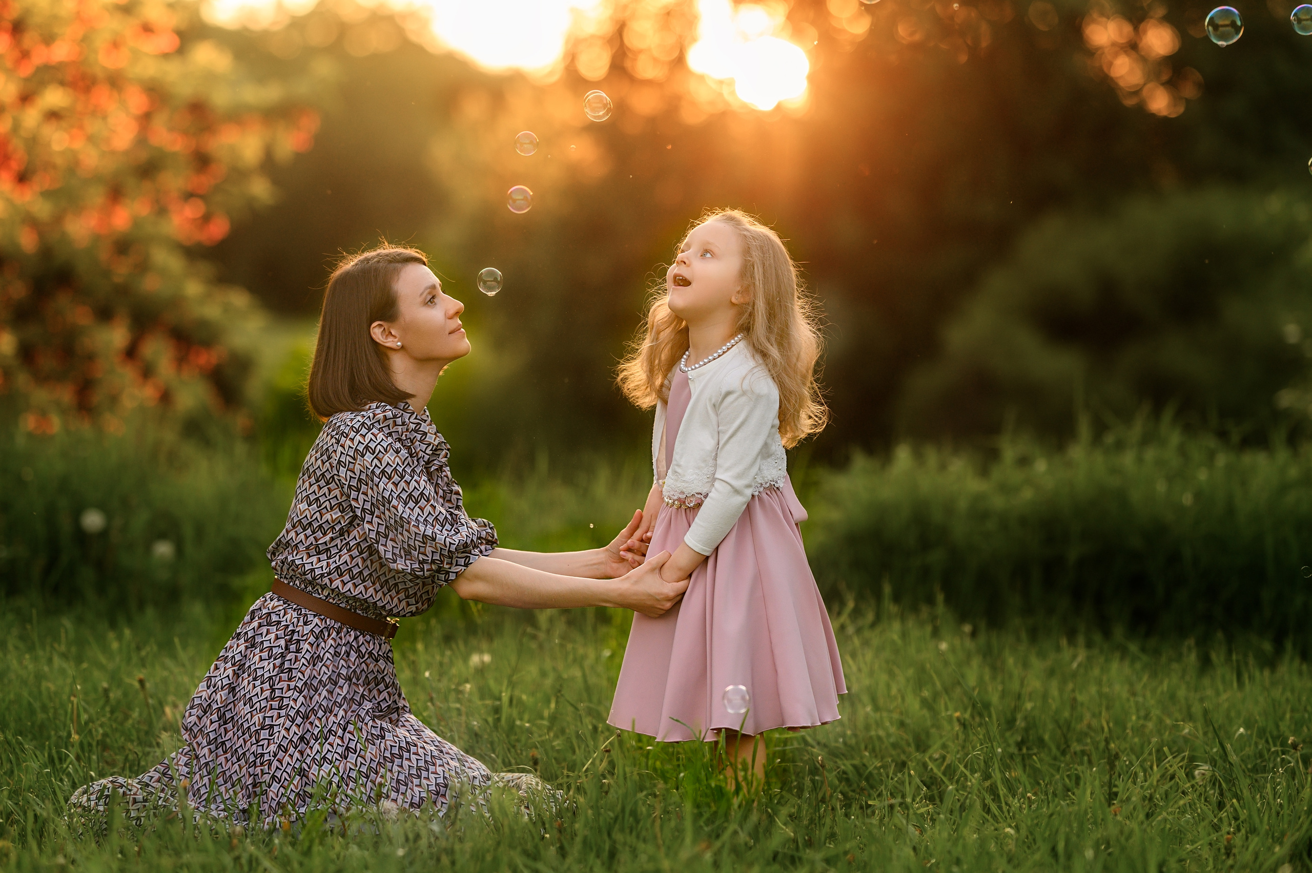 Мама нежно смотрит на маленькую дочку