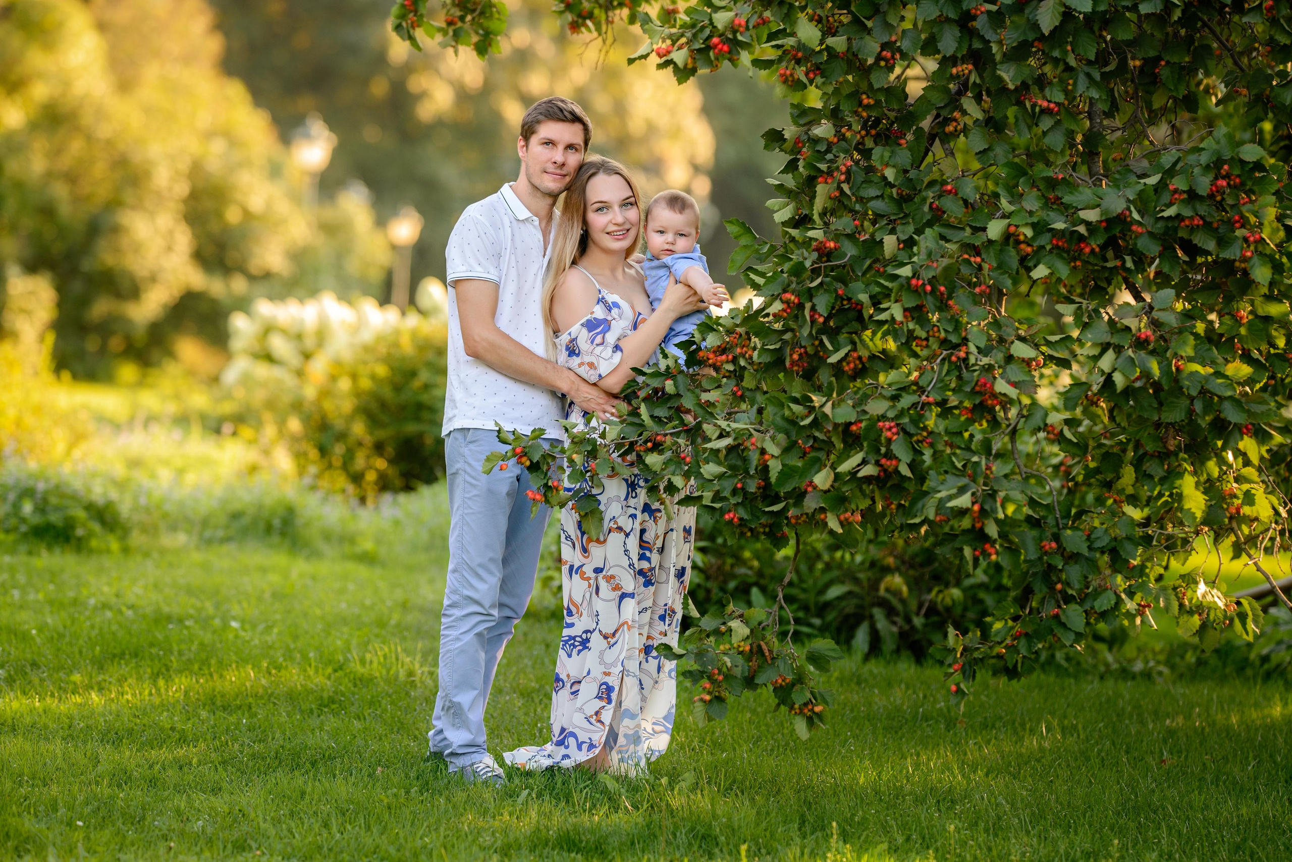 Семья стоит под кустом боярышника