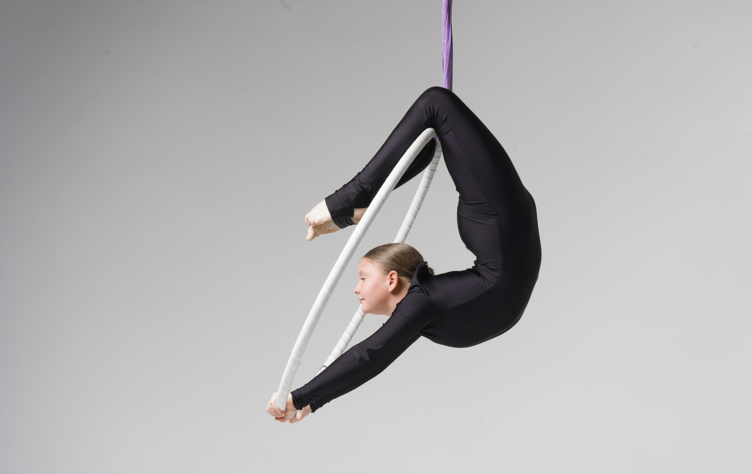 Грациозный прогиб в подвесном снаряде, художественная передача гибкости в спортивной фотографии