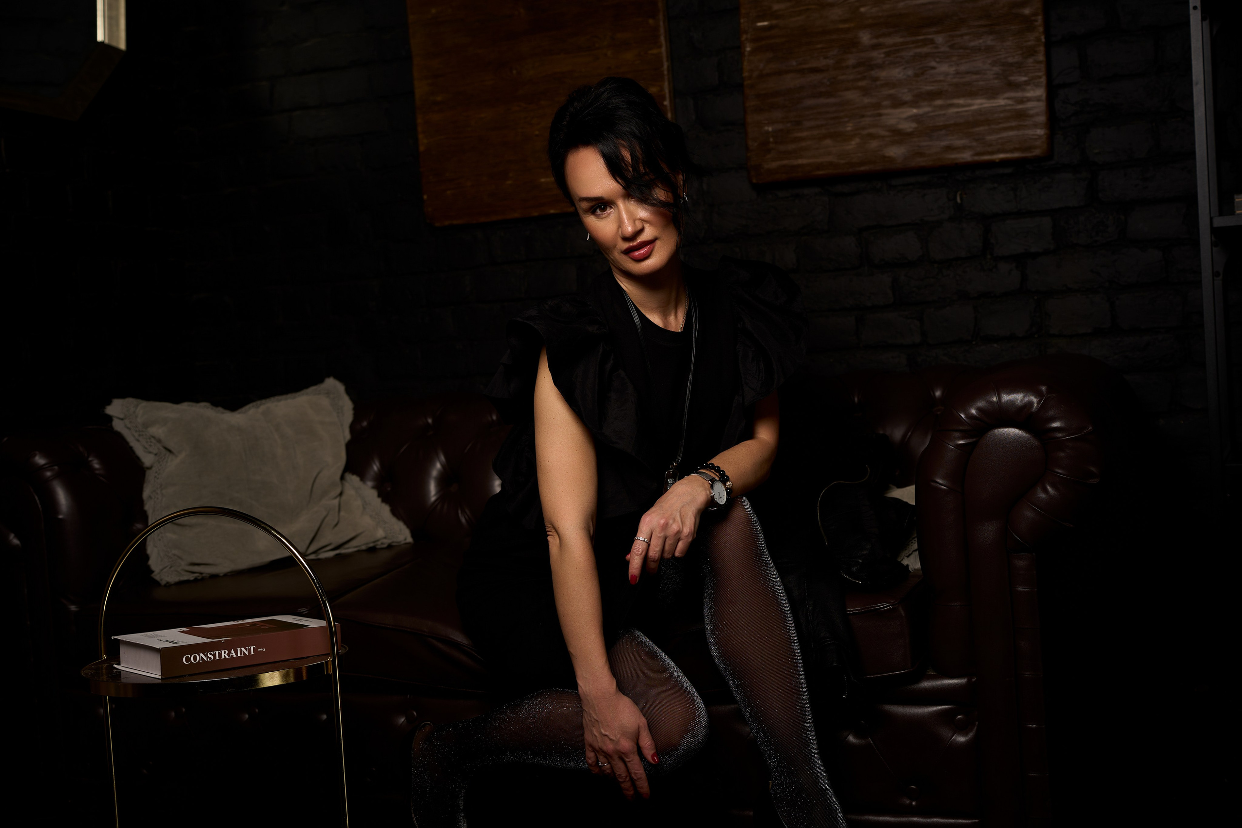 Портрет девушки в колготках на кожаном диване