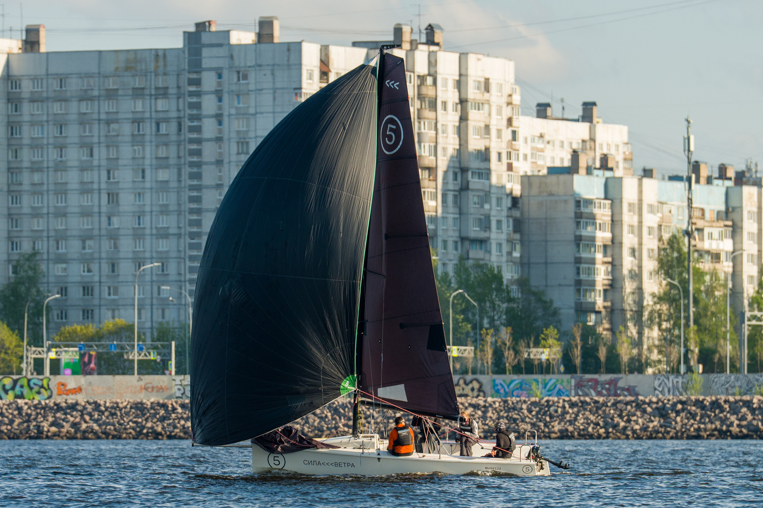 SV20 crew from Sila Vetra powers under spinnaker past the city waterfront