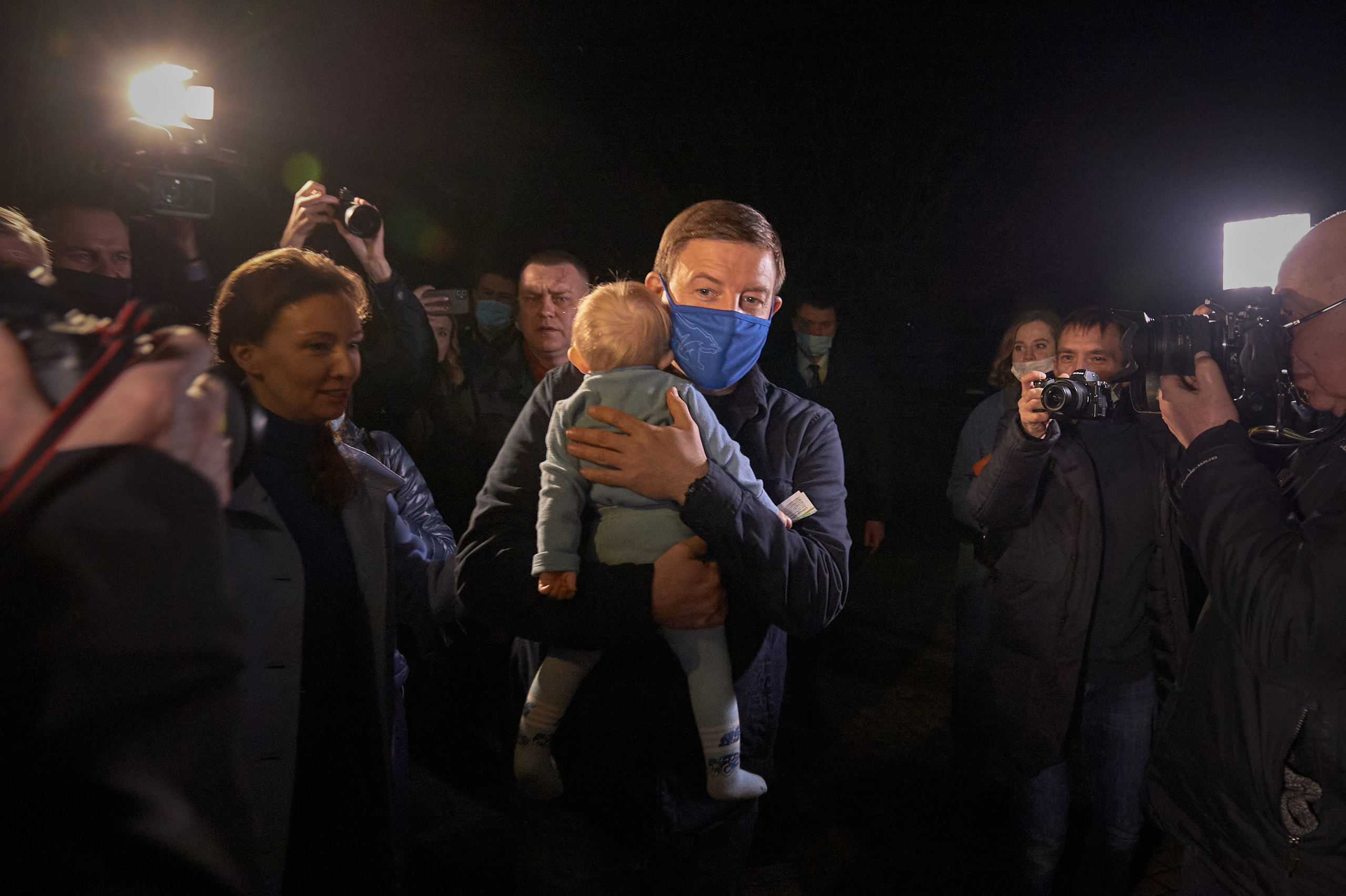 Secretary of United Russia's General Council, Andrey Turchak, carries Larisa Minasyan's child, who had run outside, back into the temporary refugee accommodation center at the Aelita Hotel in Rostov-on-Don, February 22, 2022.