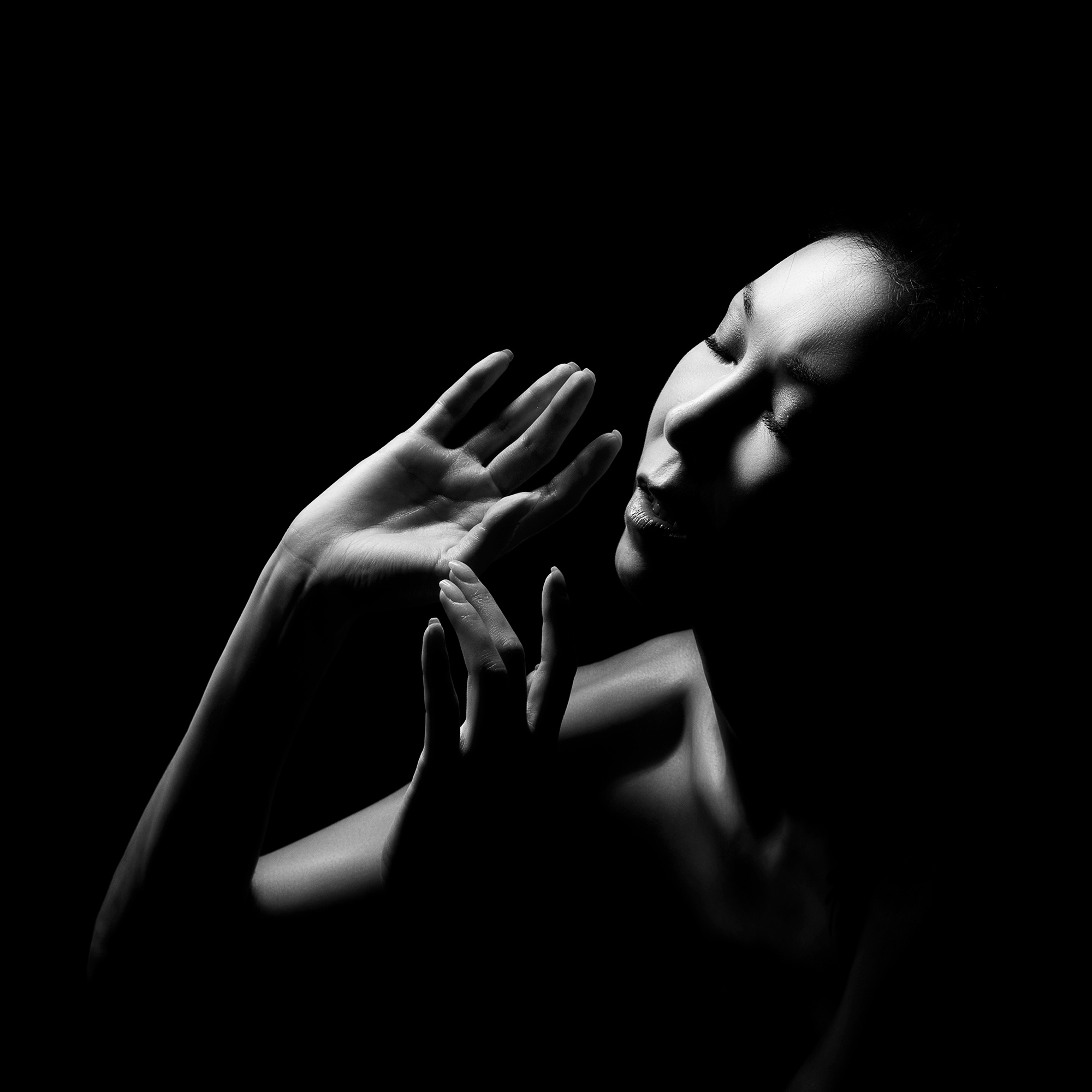 черно-белый портрет девушки в студии на черном фоне