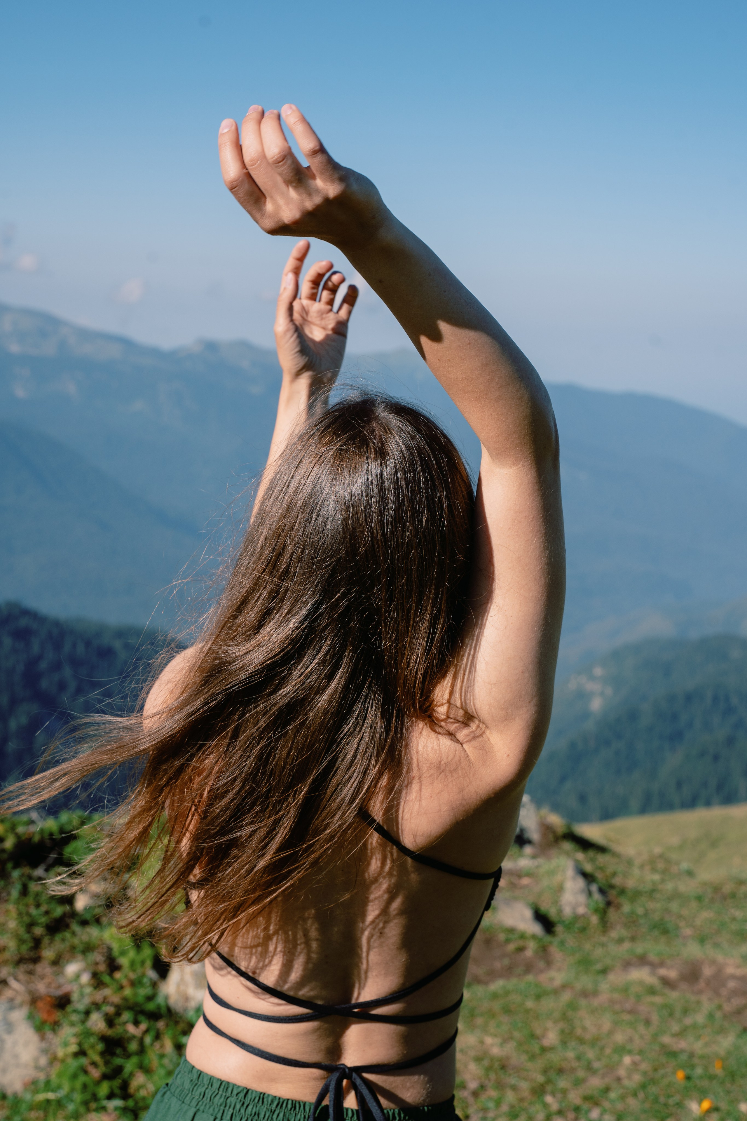 Снимок девушки со спины на фоне гор