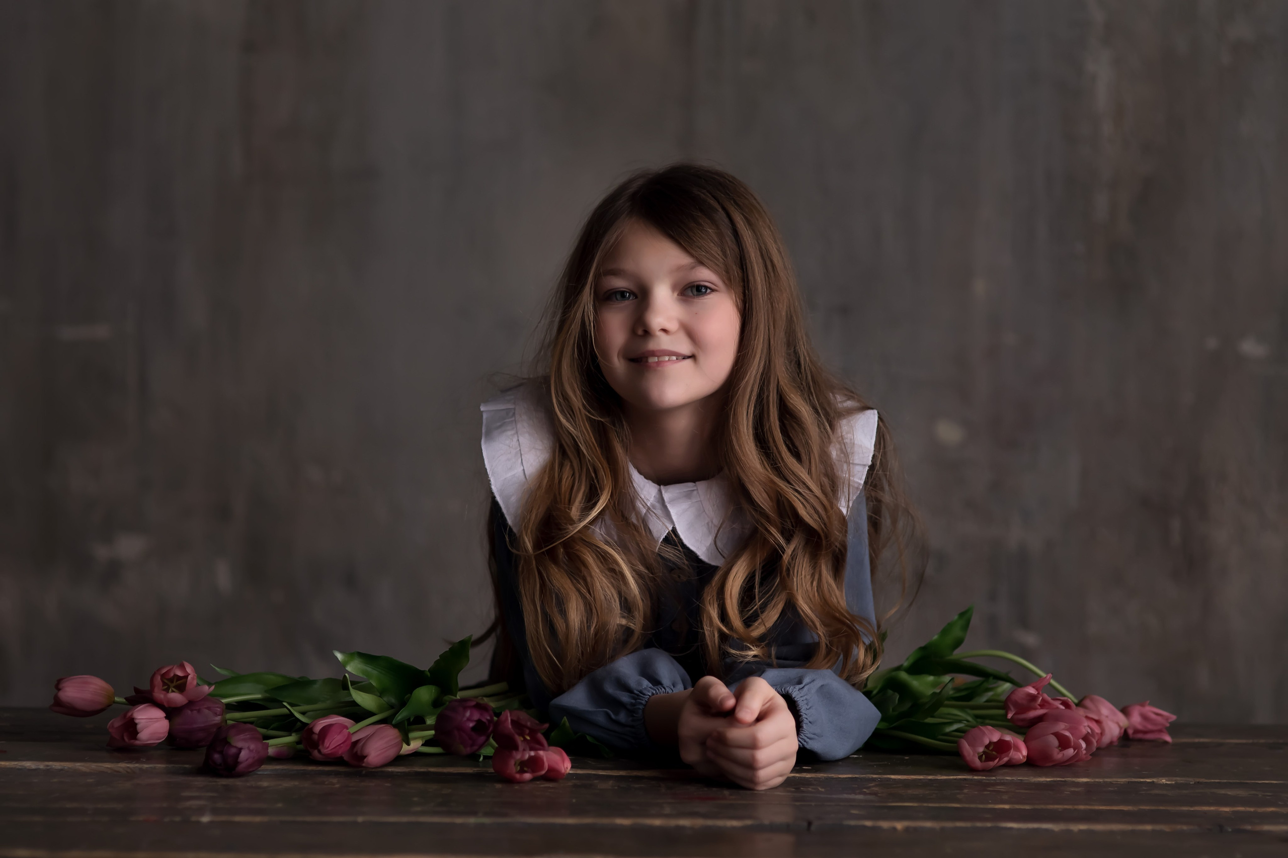 красивая девочка сидит в окружении цветов