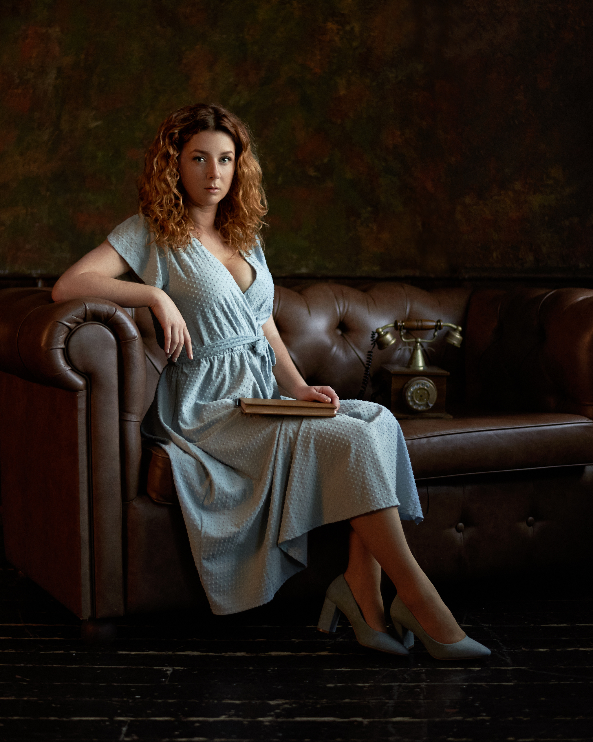 Классический портрет рыжей девушки в голубом платье на диване 