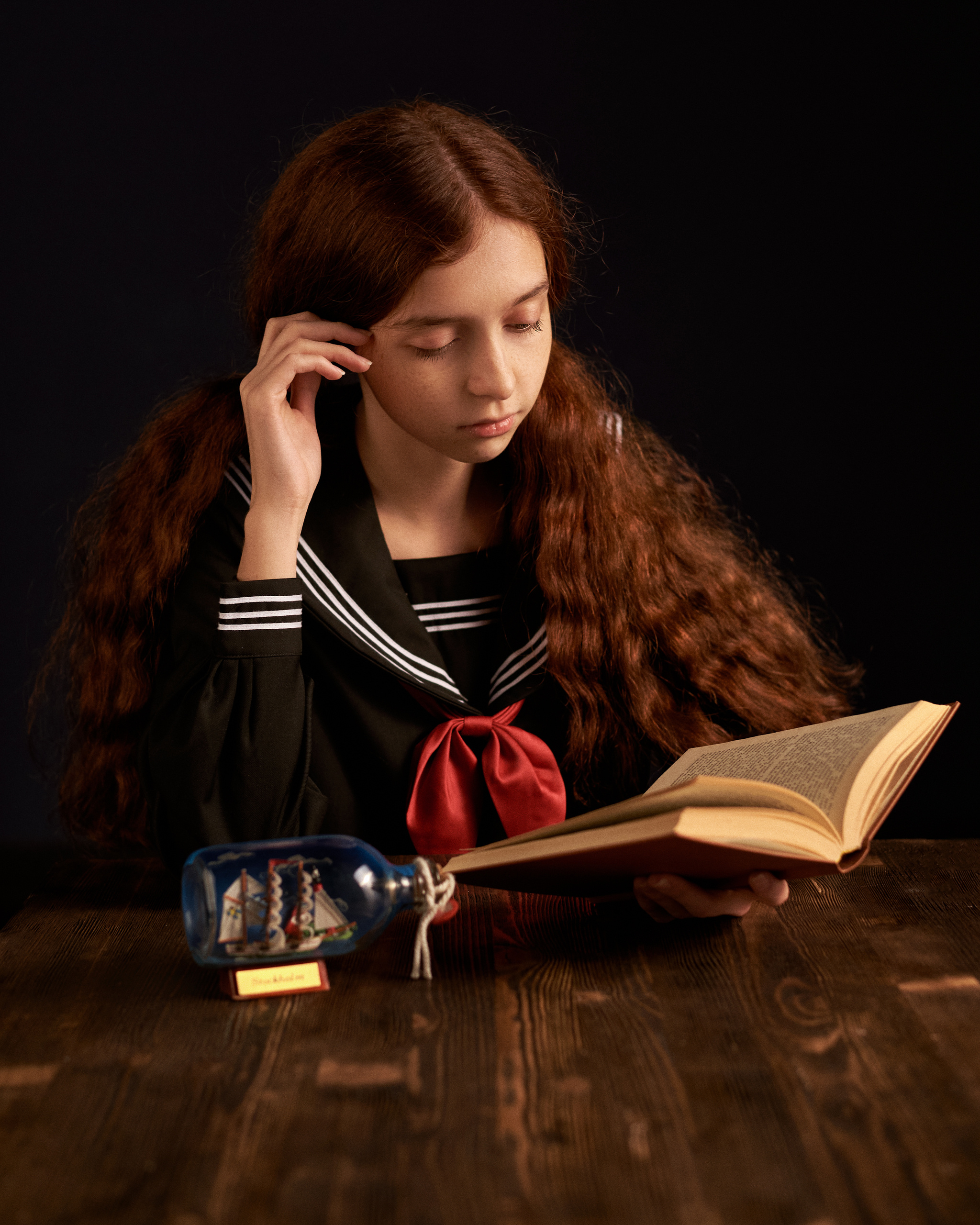 Девочка в морской форме читает романтическую книгу 