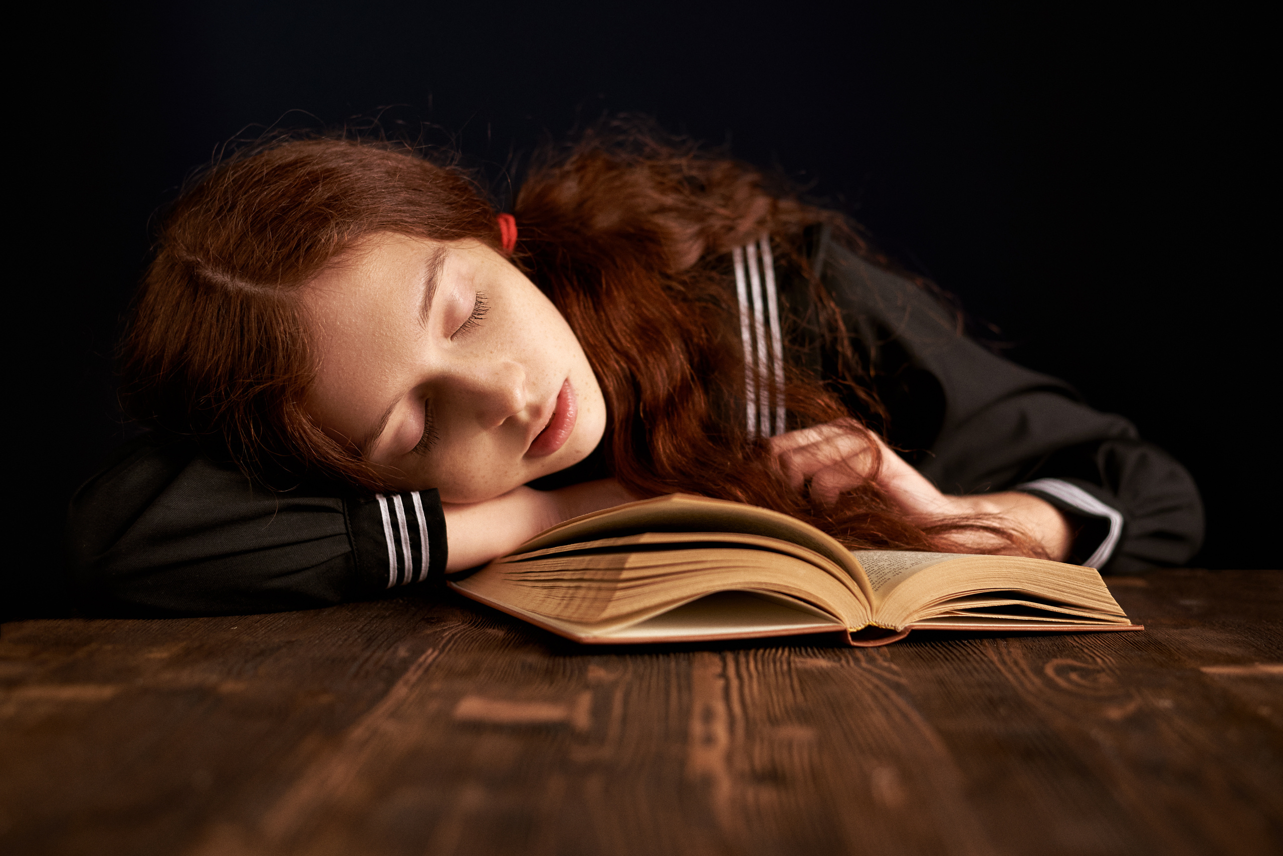 Ребенок уснул за чтением любимой книги и видит красивые сны 