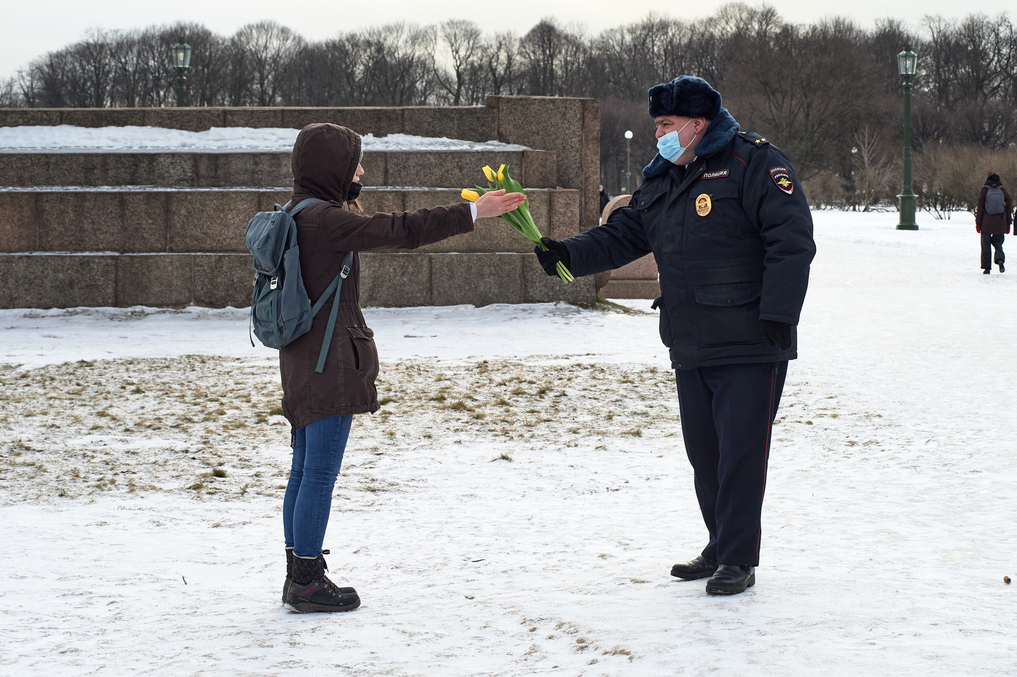 Полицейский пытается подарить тюльпаны фемактивистке 8 марта