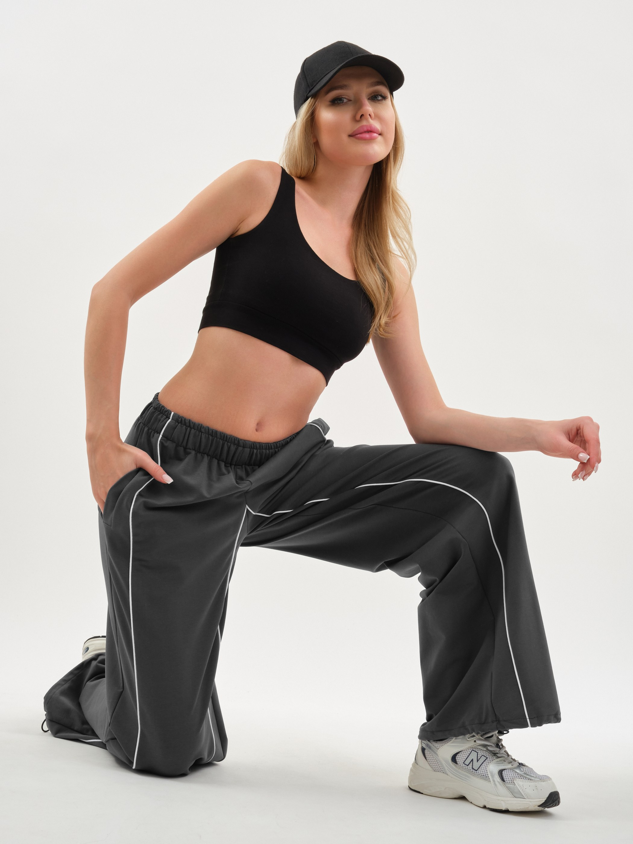 Девушка сидит в кепке и спортивных штанах