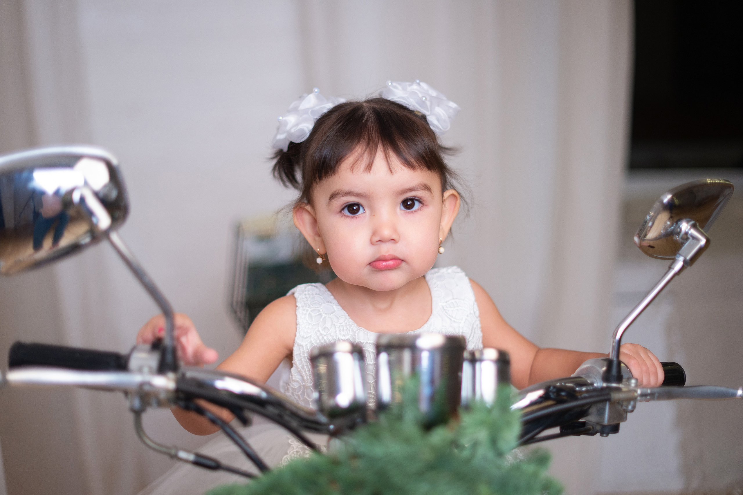 Девочка сидит на скутере и смотрит в камеру в пространстве фотостудии Амальгама в Саратове.