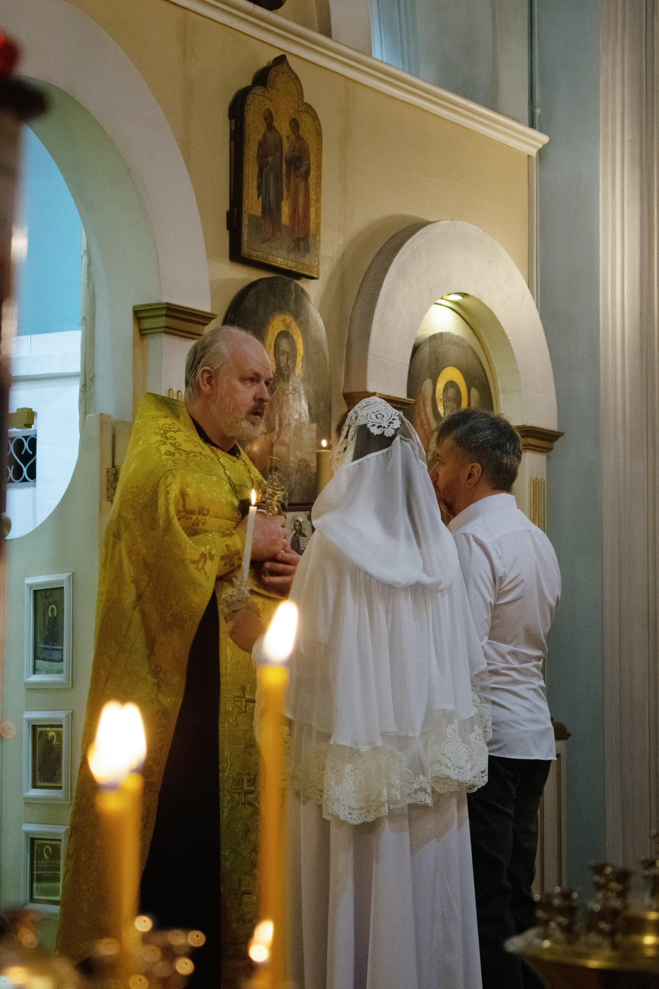 Церемония венчания в храме. Священник благословляет молодых. Свадебная фотосессия в Сортавала, Карелия.