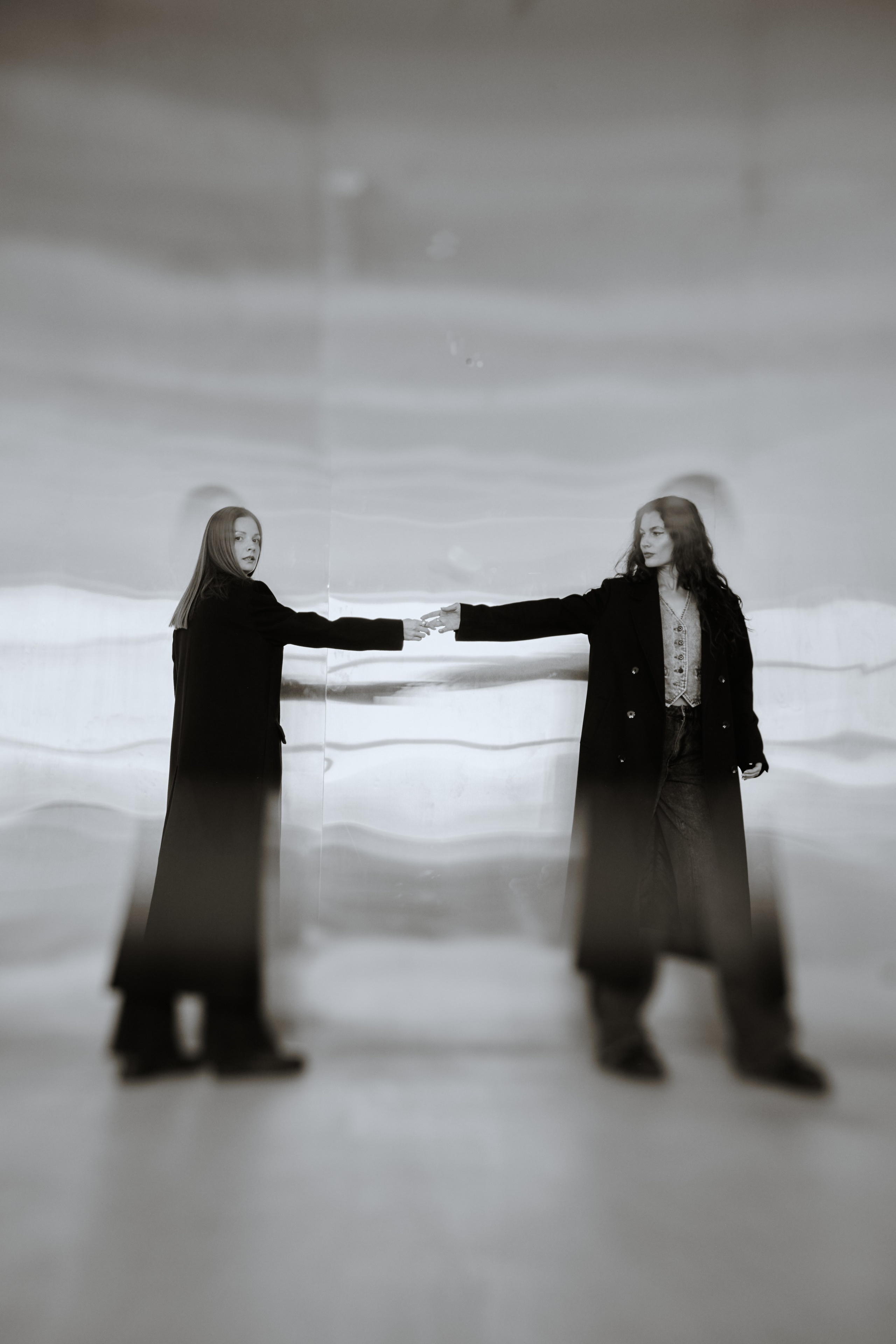 Две девушки стоят на фоне металлической стены в движении. Виктория Брызгалова и Анна Пижонкова