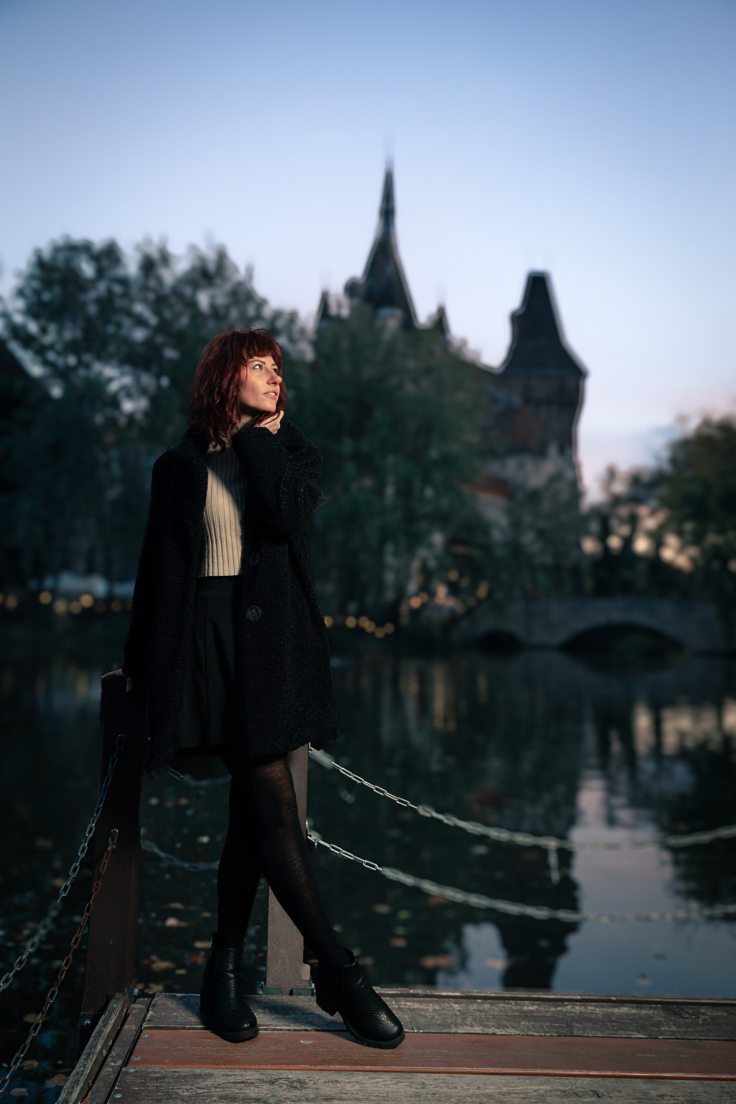 A walking photo in Budapest. A girl with the castle and sunset in the background.